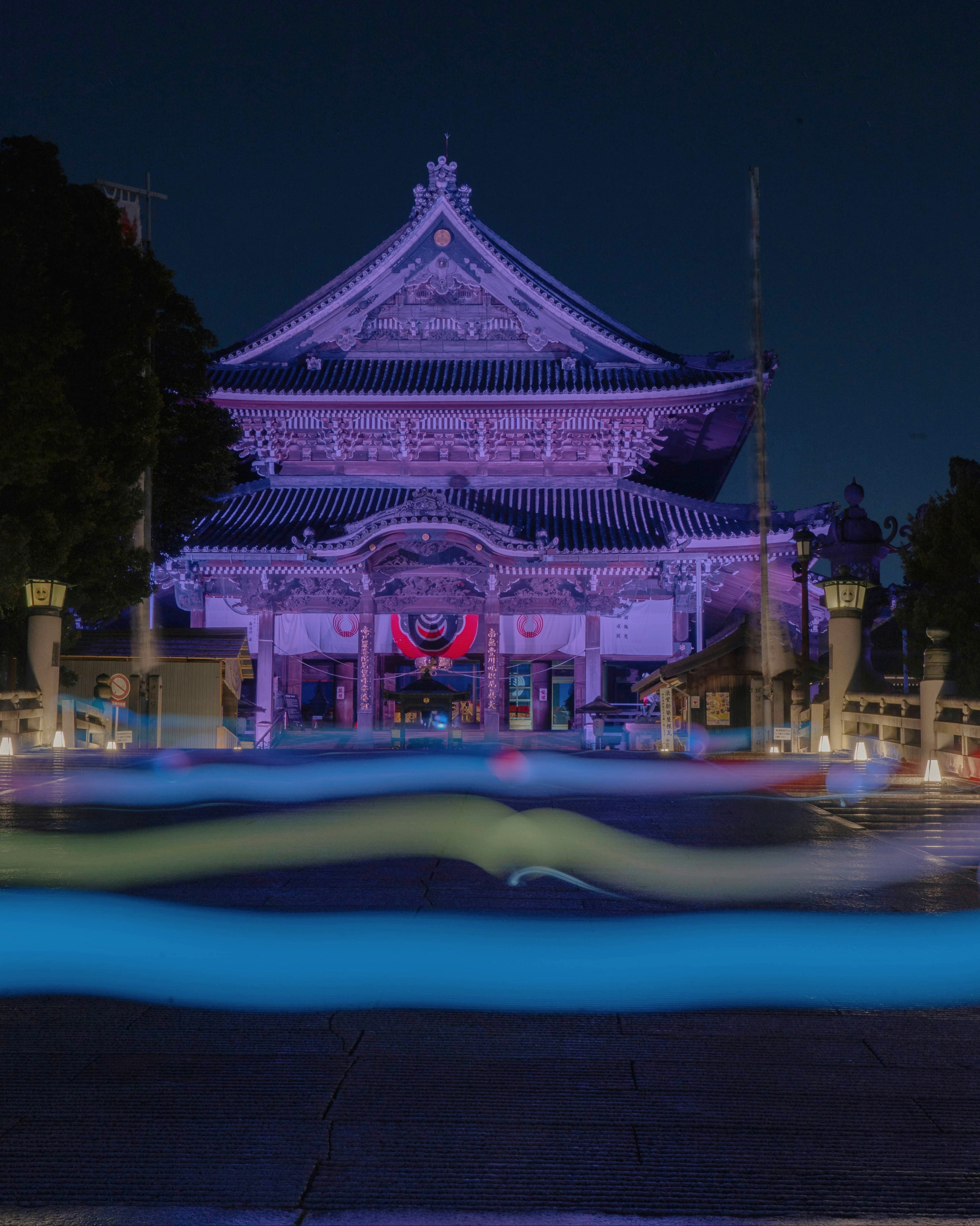 夜の紫色の照明で照らされた伝統的な日本の寺院の美しい外観