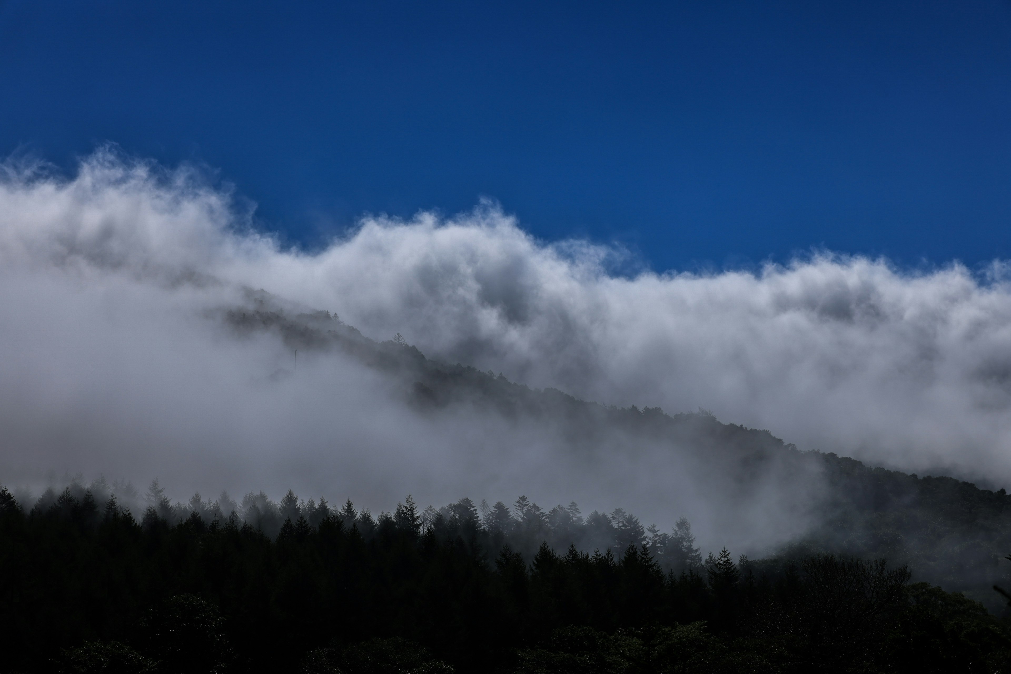 Pemandangan pegunungan dengan langit biru dan awan putih