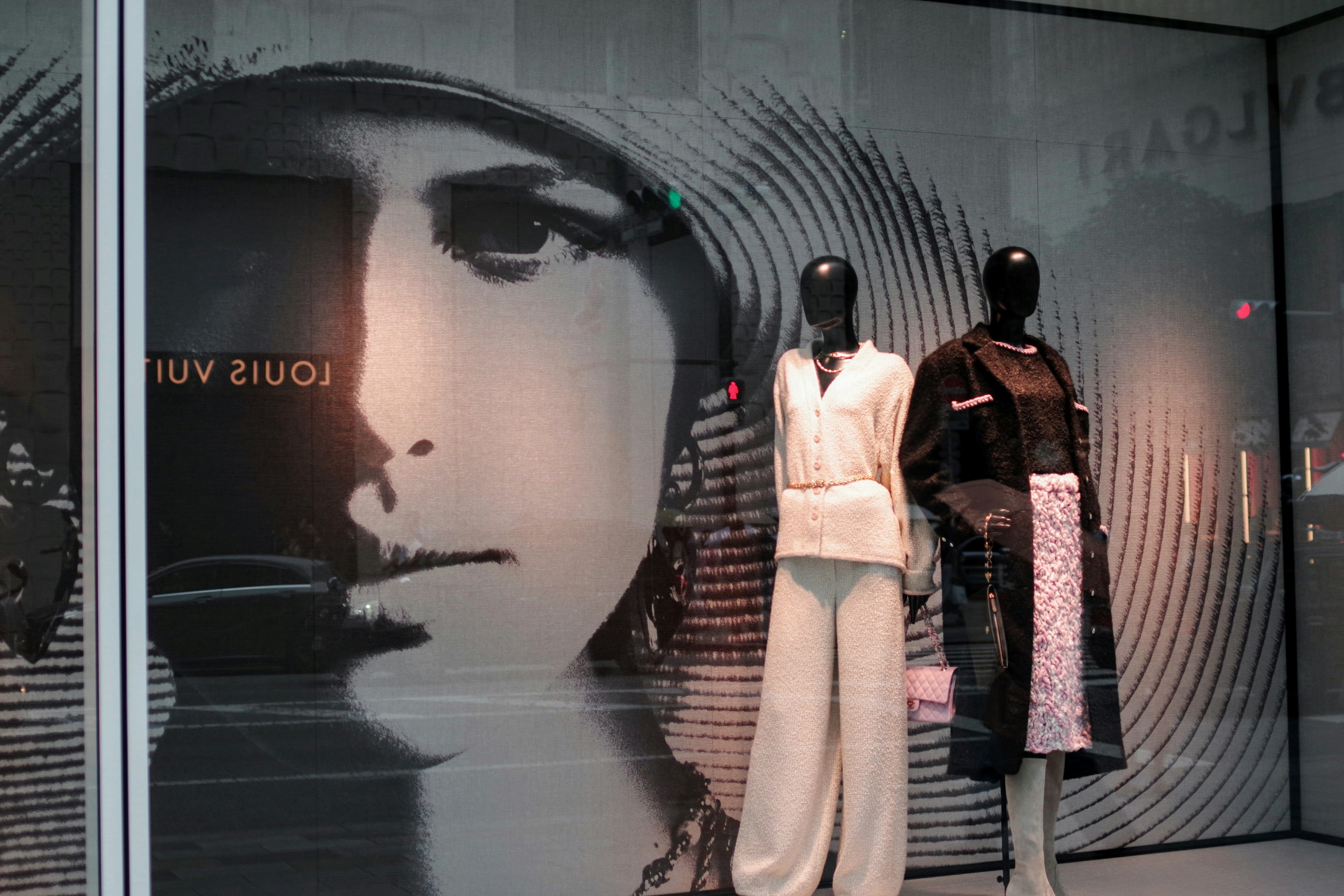 Fashion display featuring two mannequins and a large face graphic