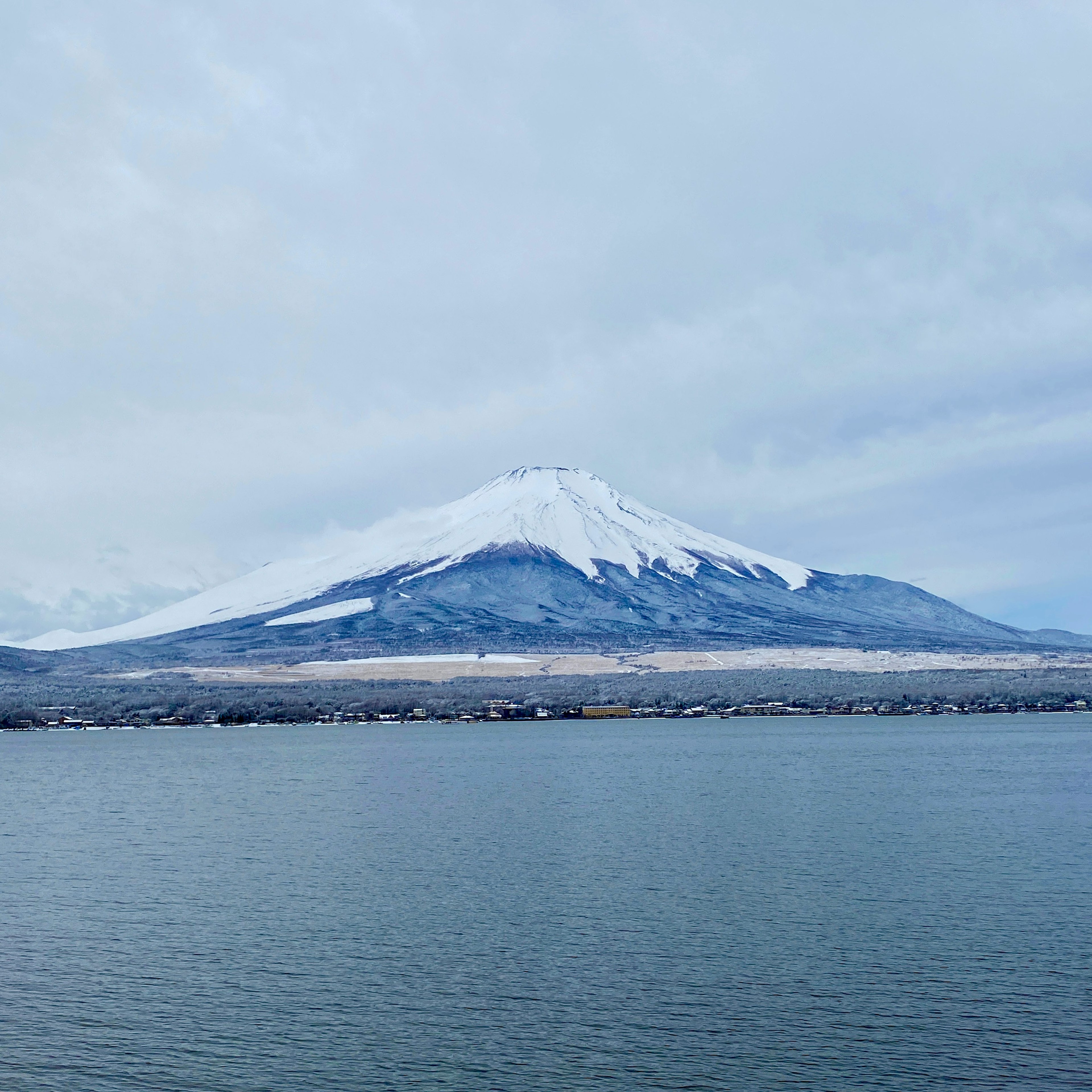 Scenic view of snow-capped Mount Fuji and a calm lake