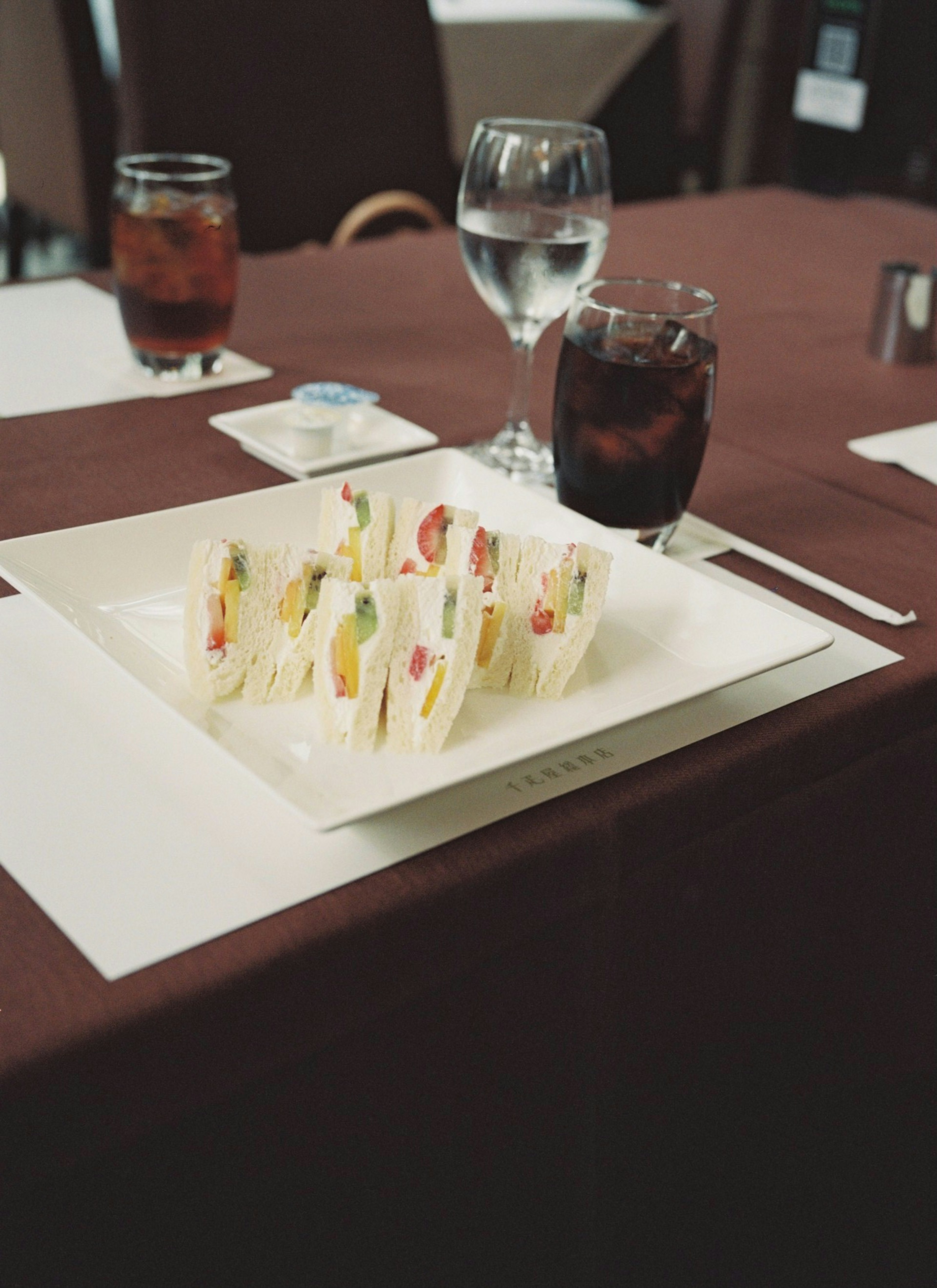 Colorful sandwich platter on a table with drinks