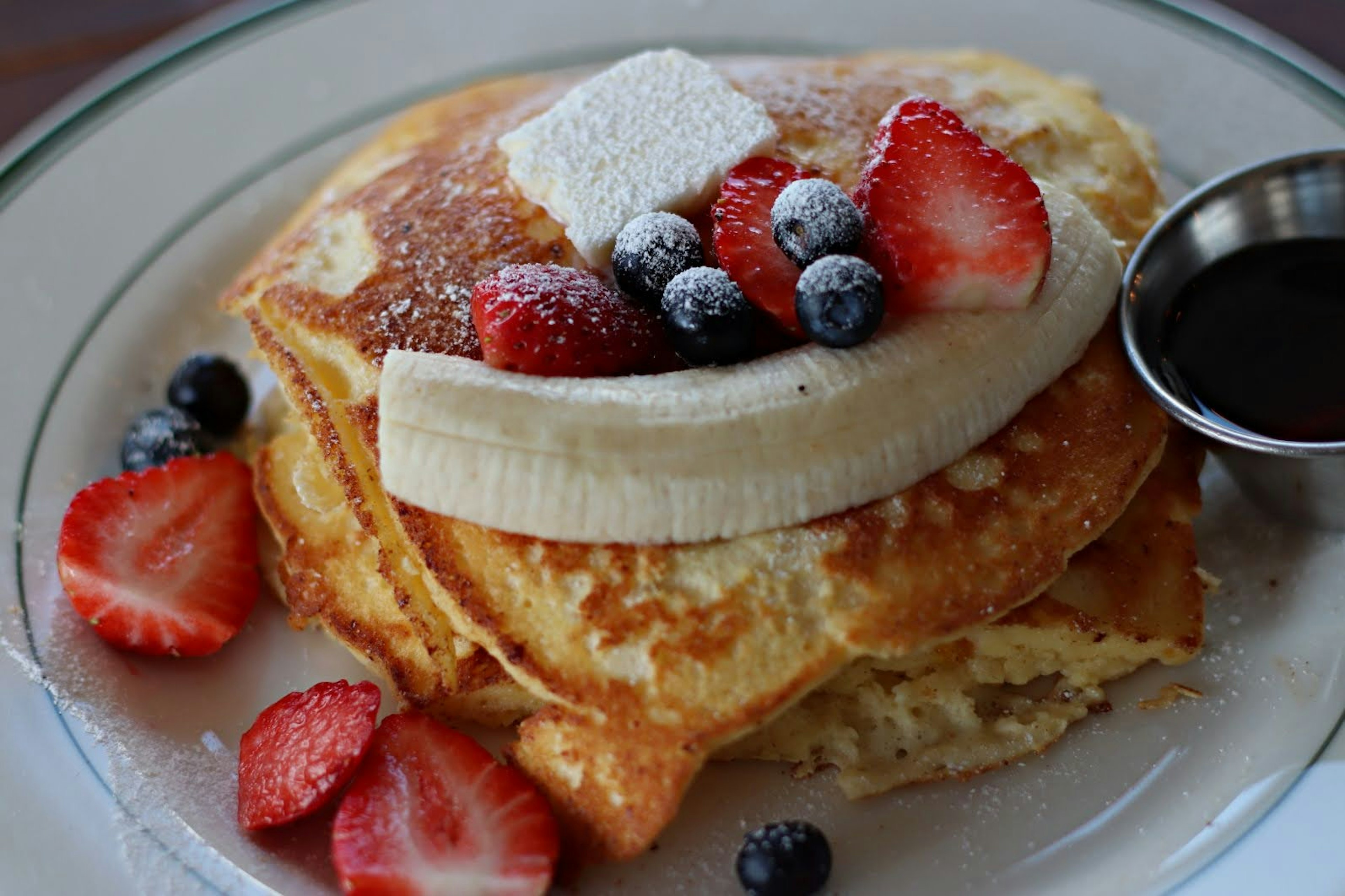 Fluffy pancakes topped with banana and mixed berries