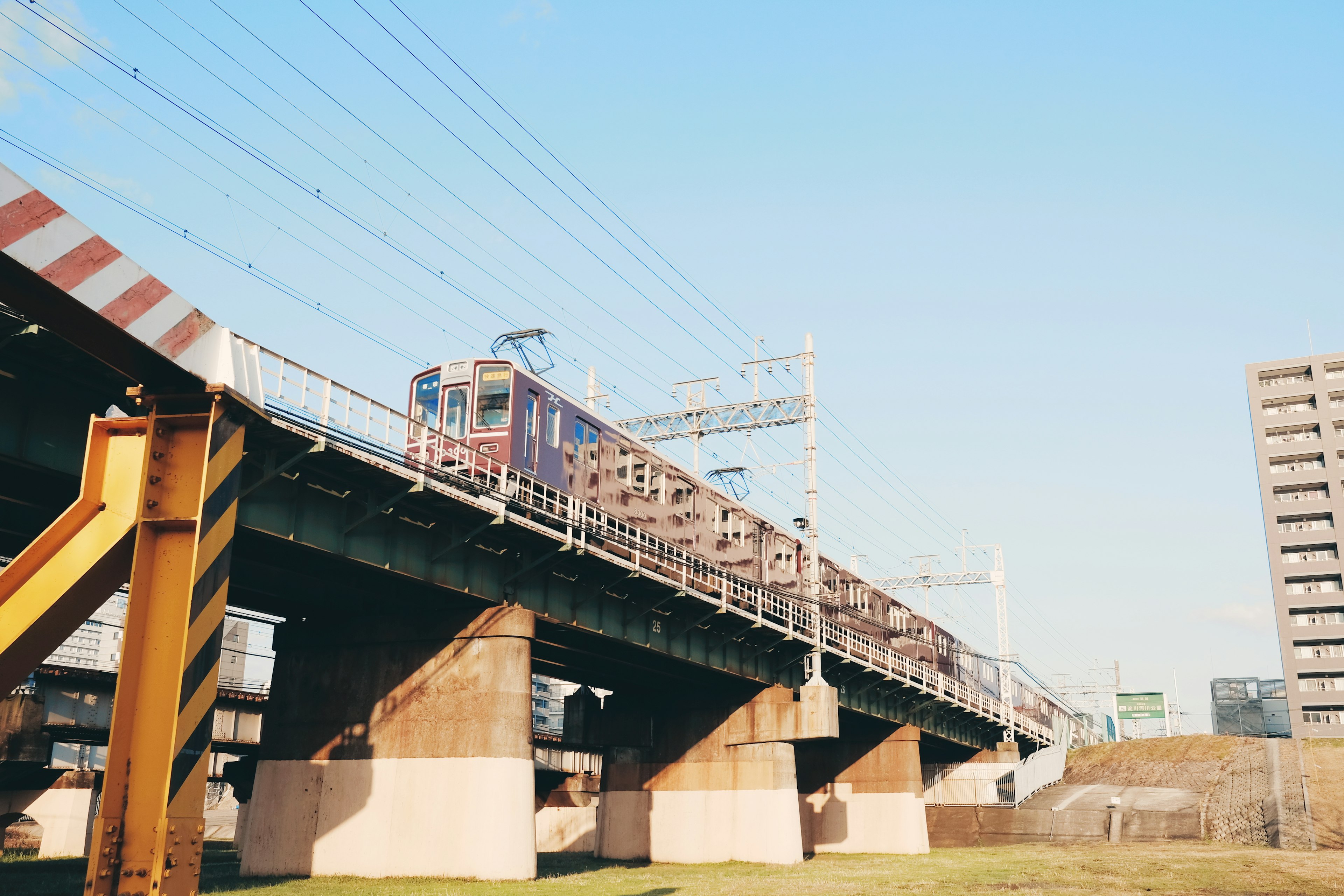 รถไฟฟ้าสูงที่วิ่งอยู่ใต้ท้องฟ้าสีฟ้า