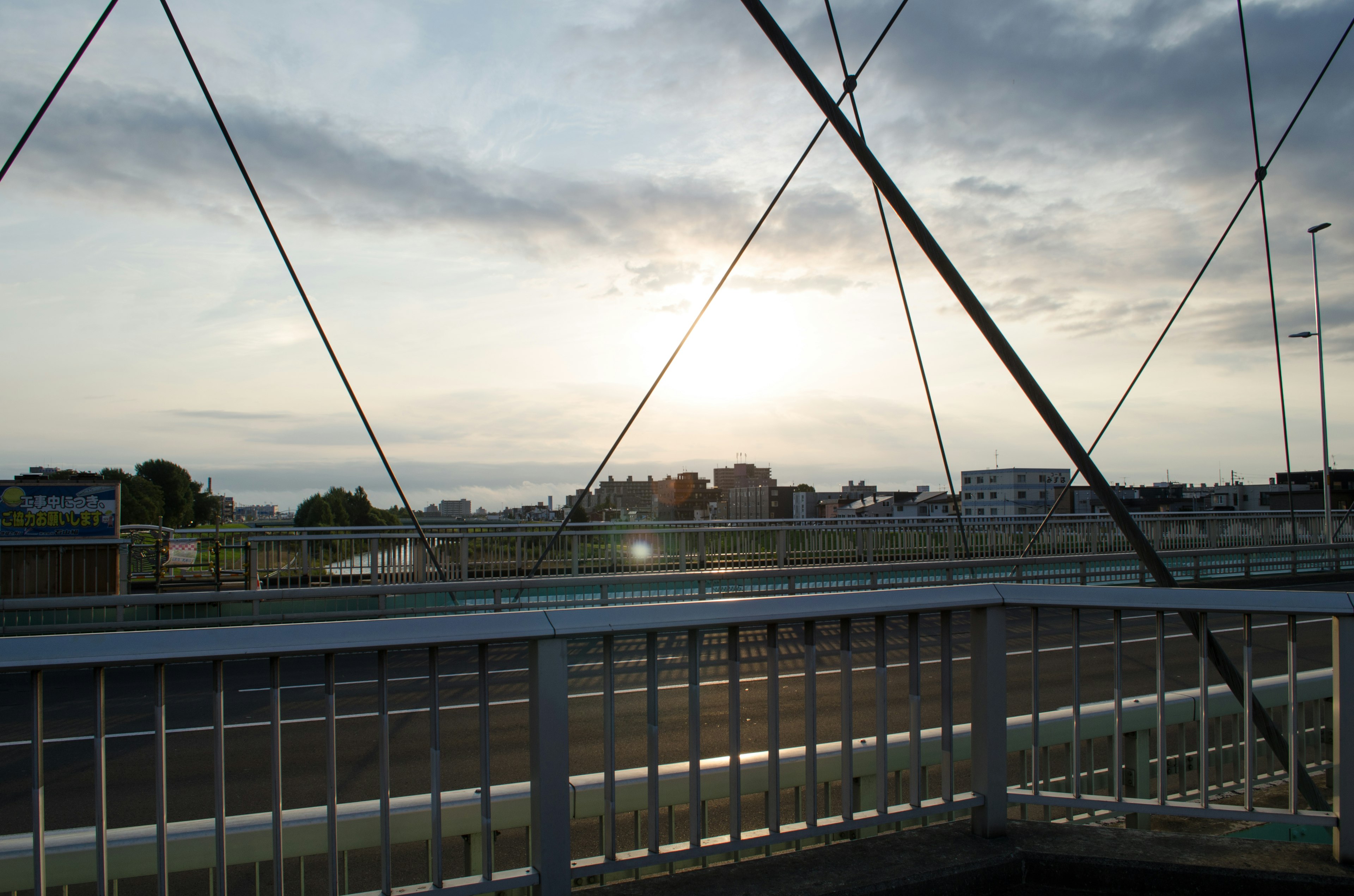 Blick auf einen Sonnenuntergang über einer Brücke mit Stadtsilhouette