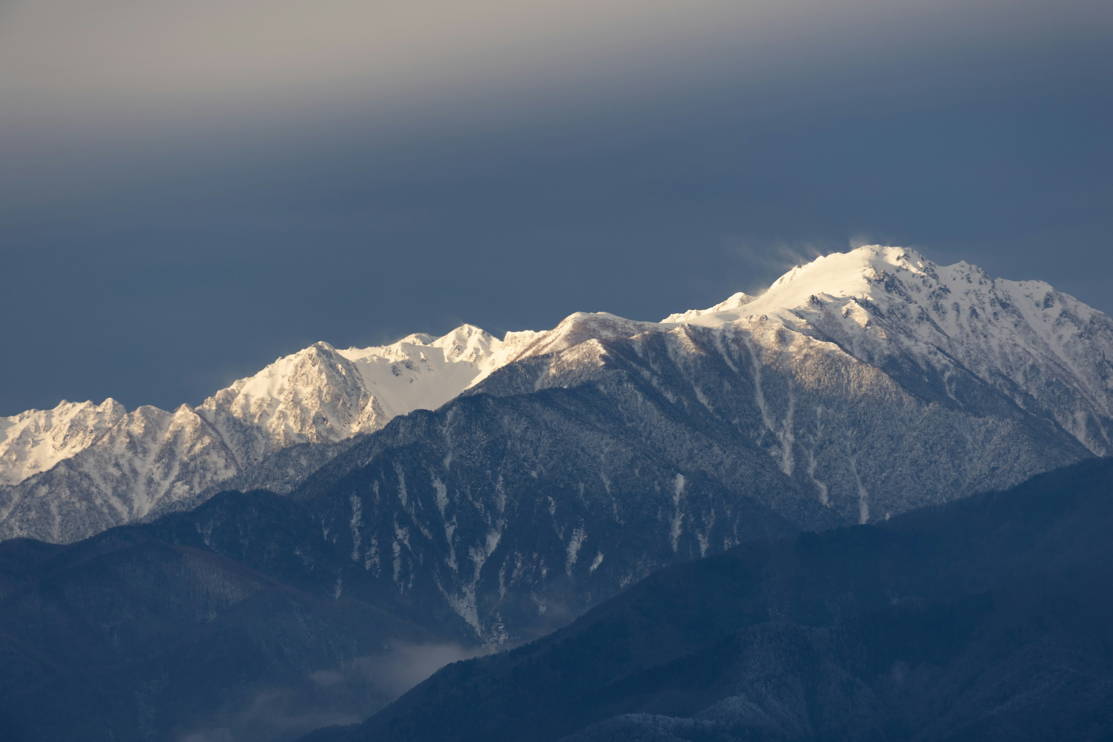 雪に覆われた山々と暗い空の風景