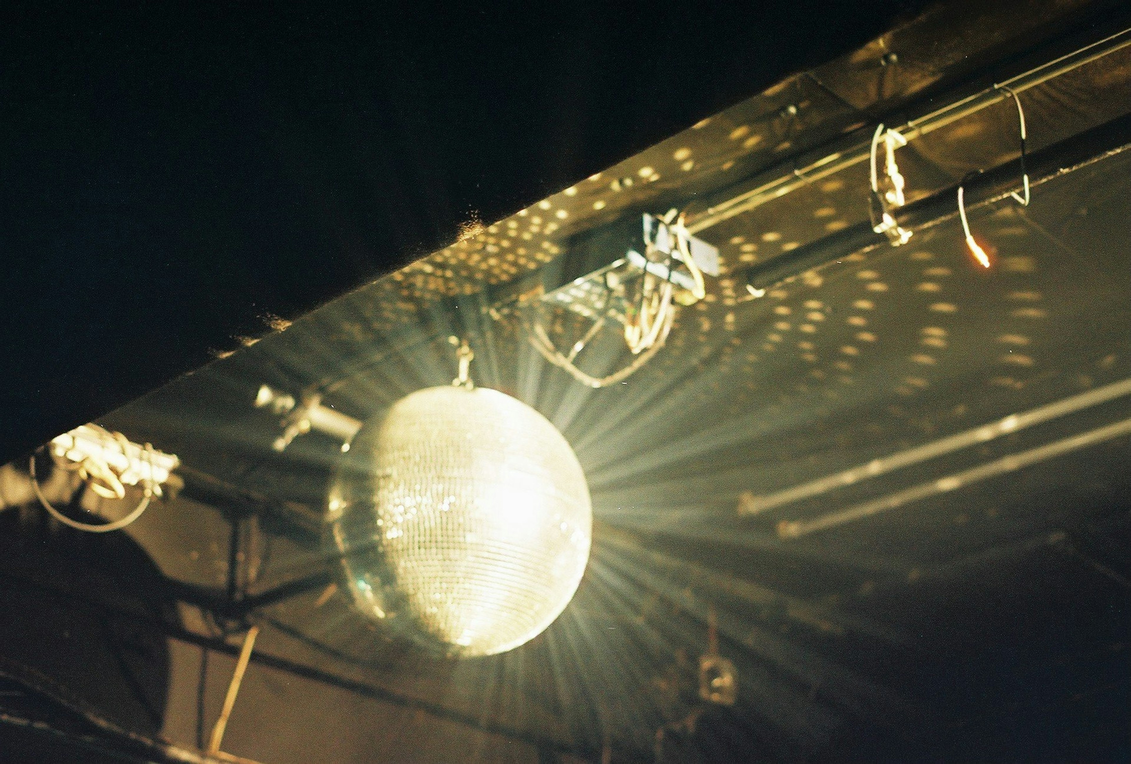 Disco ball splendente con raggi di luce in un ambiente scuro