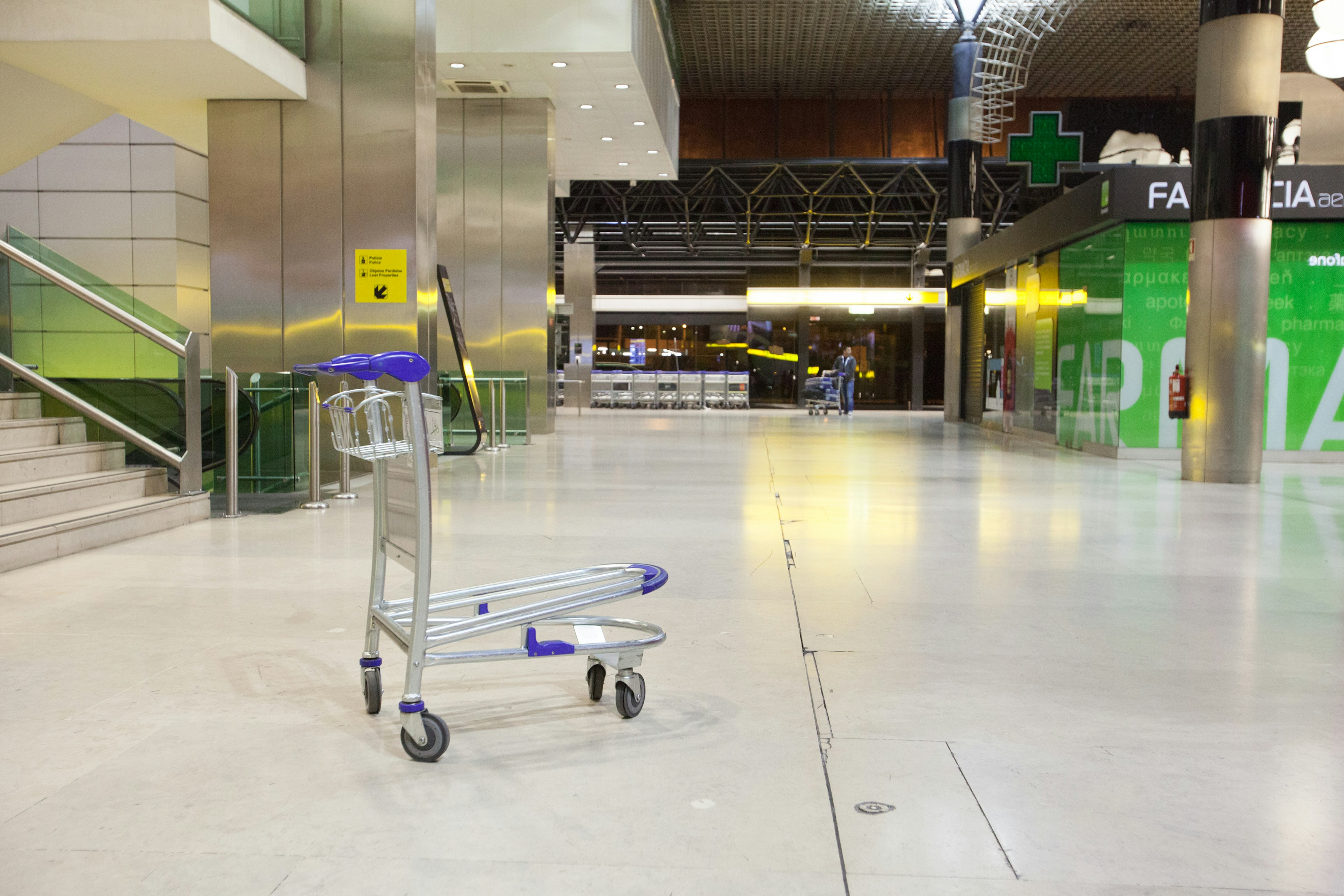 Empty airport lobby with a luggage cart