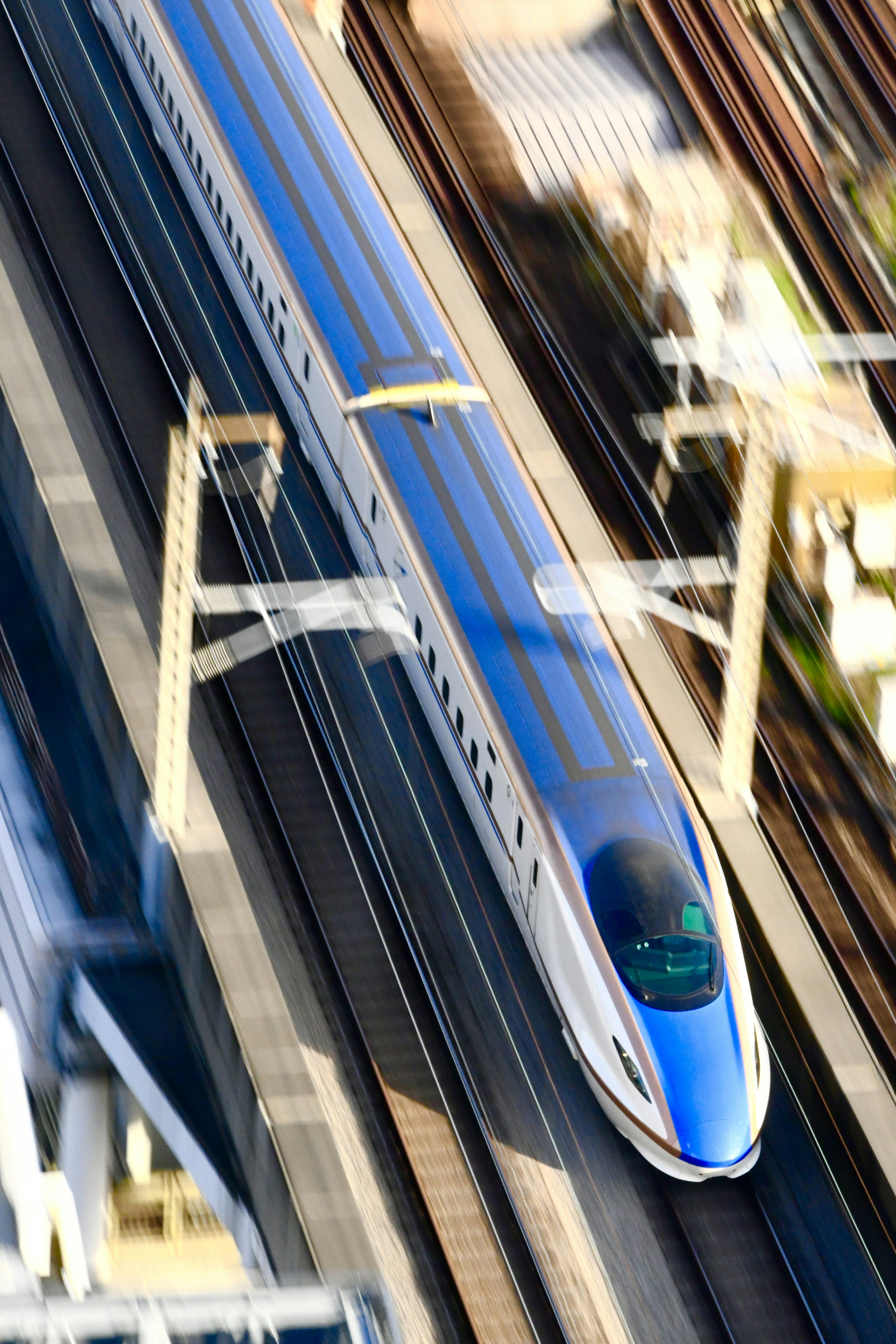 Shinkansen speeding along the tracks from an aerial perspective