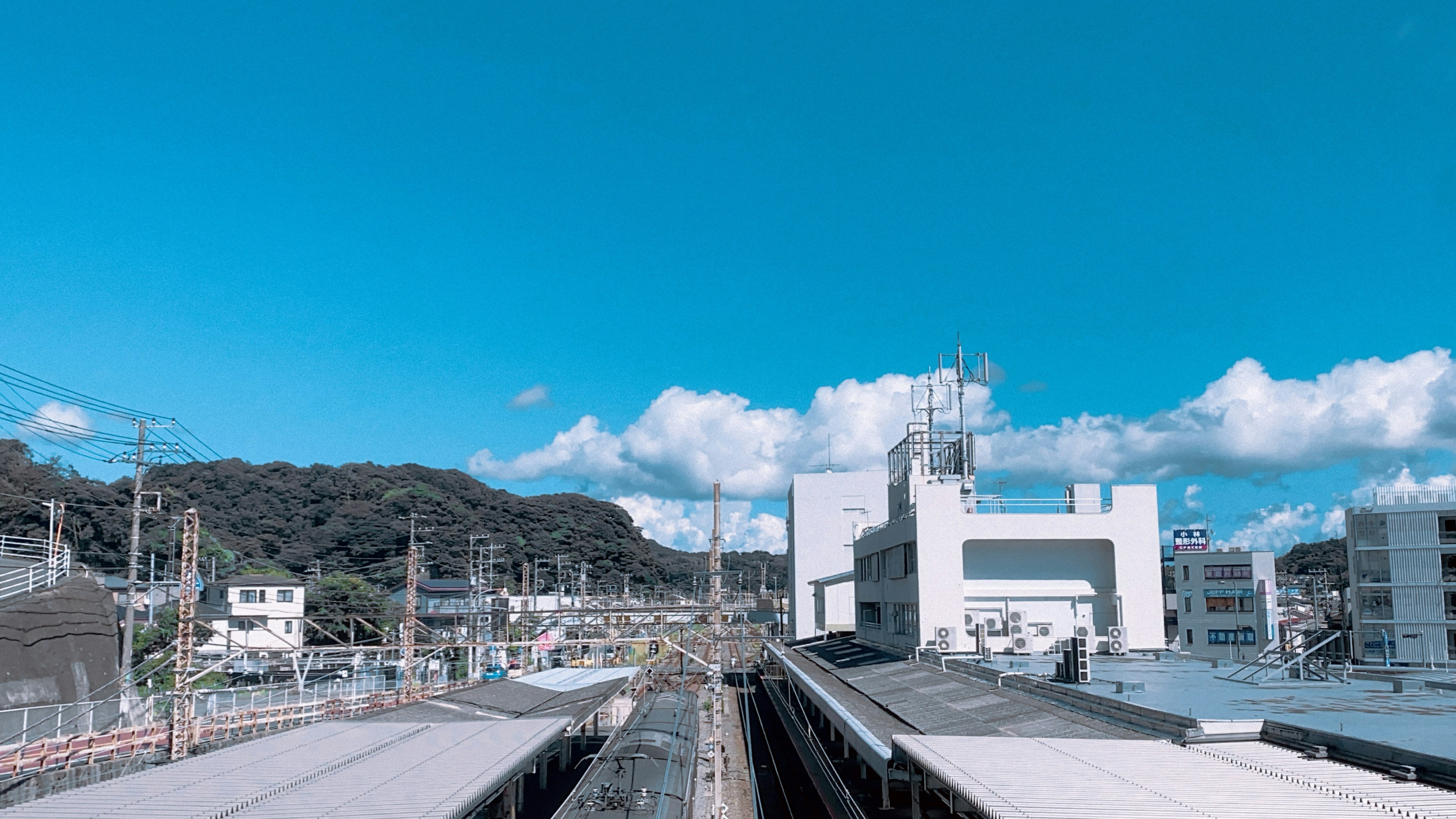 青空の下に広がる駅の風景と山々