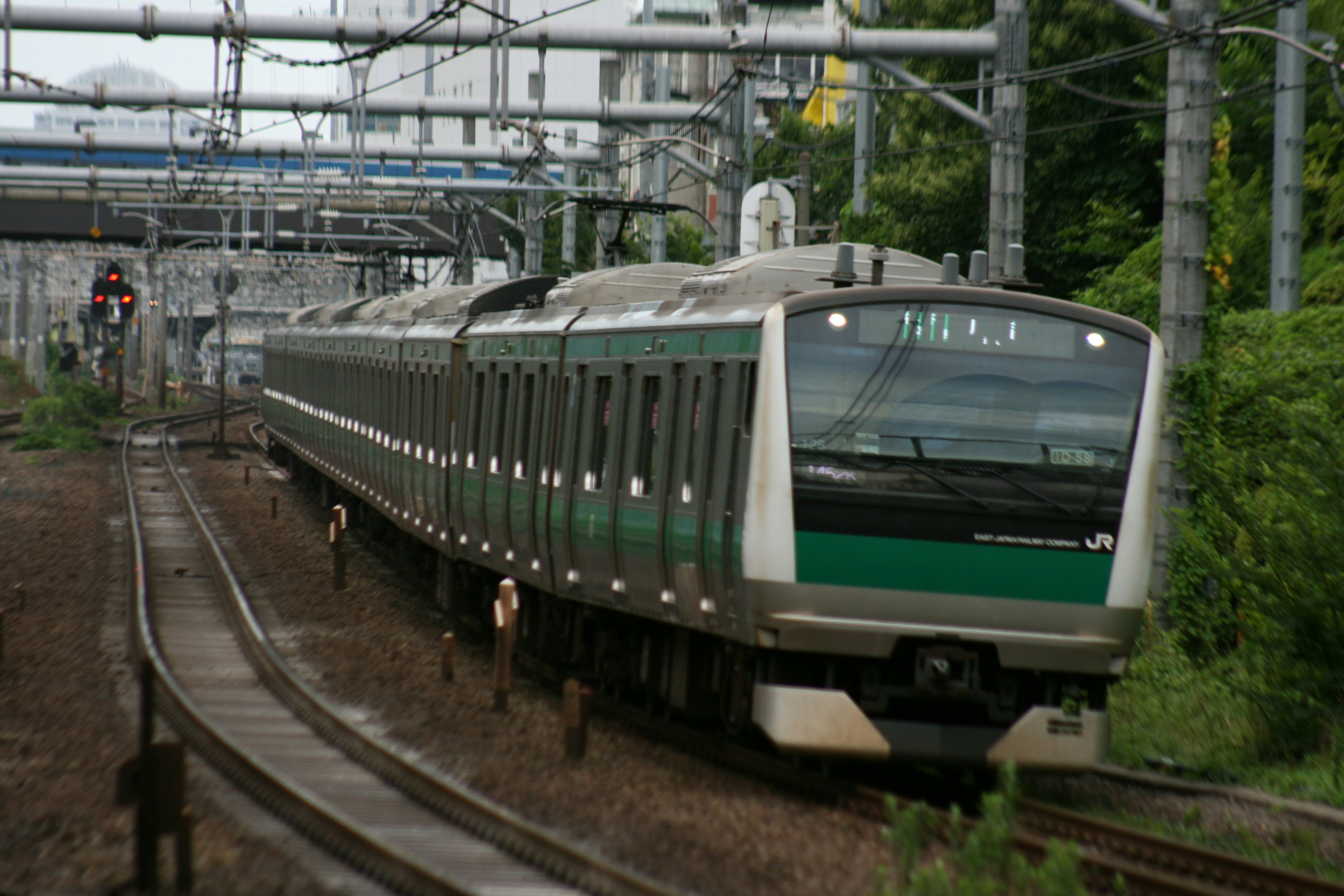 Treno verde che viaggia su binari