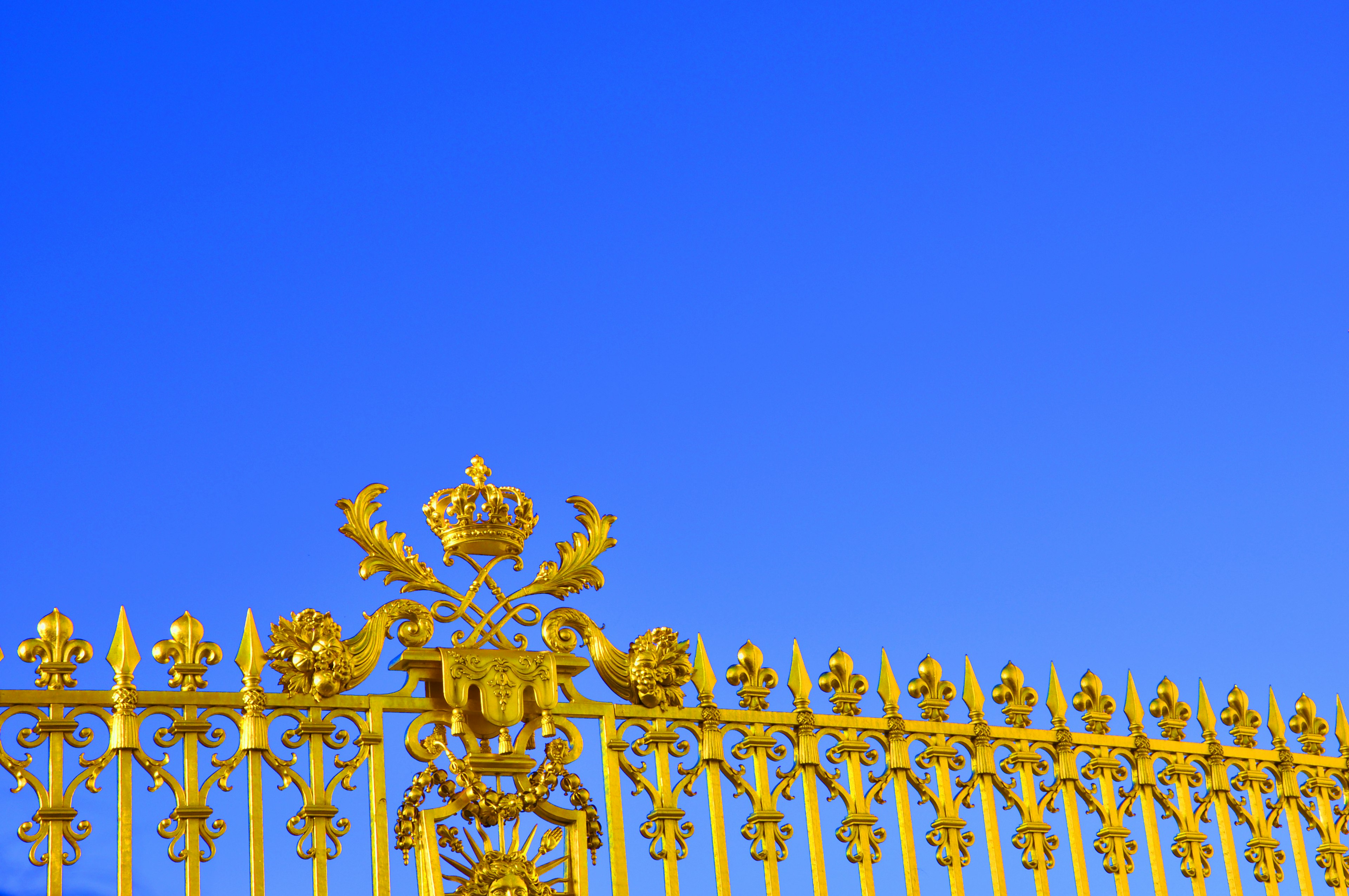 Valla dorada lujosa con diseños ornamentales contra un cielo azul