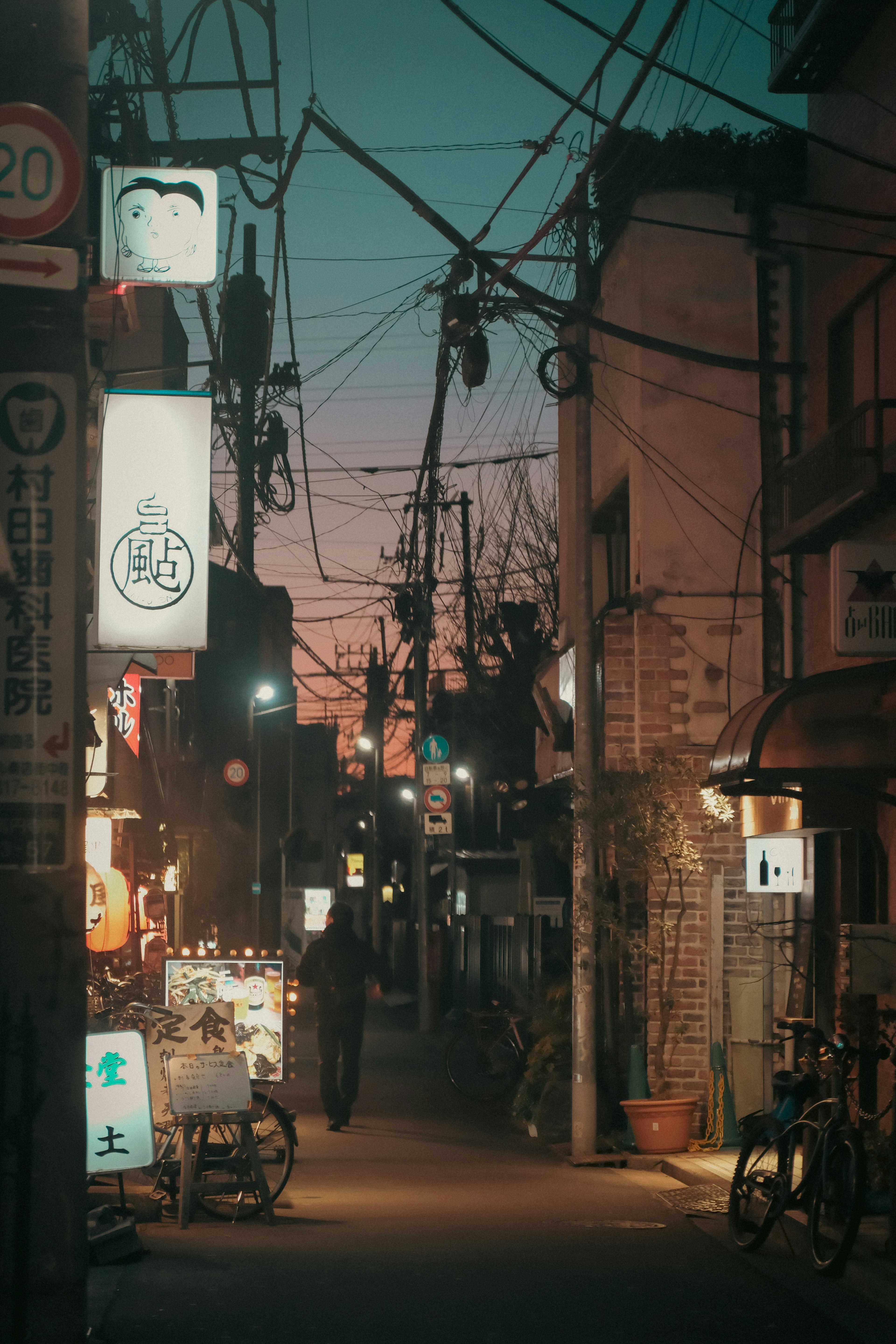 Narrow alley in Japan during twilight with intersecting power lines