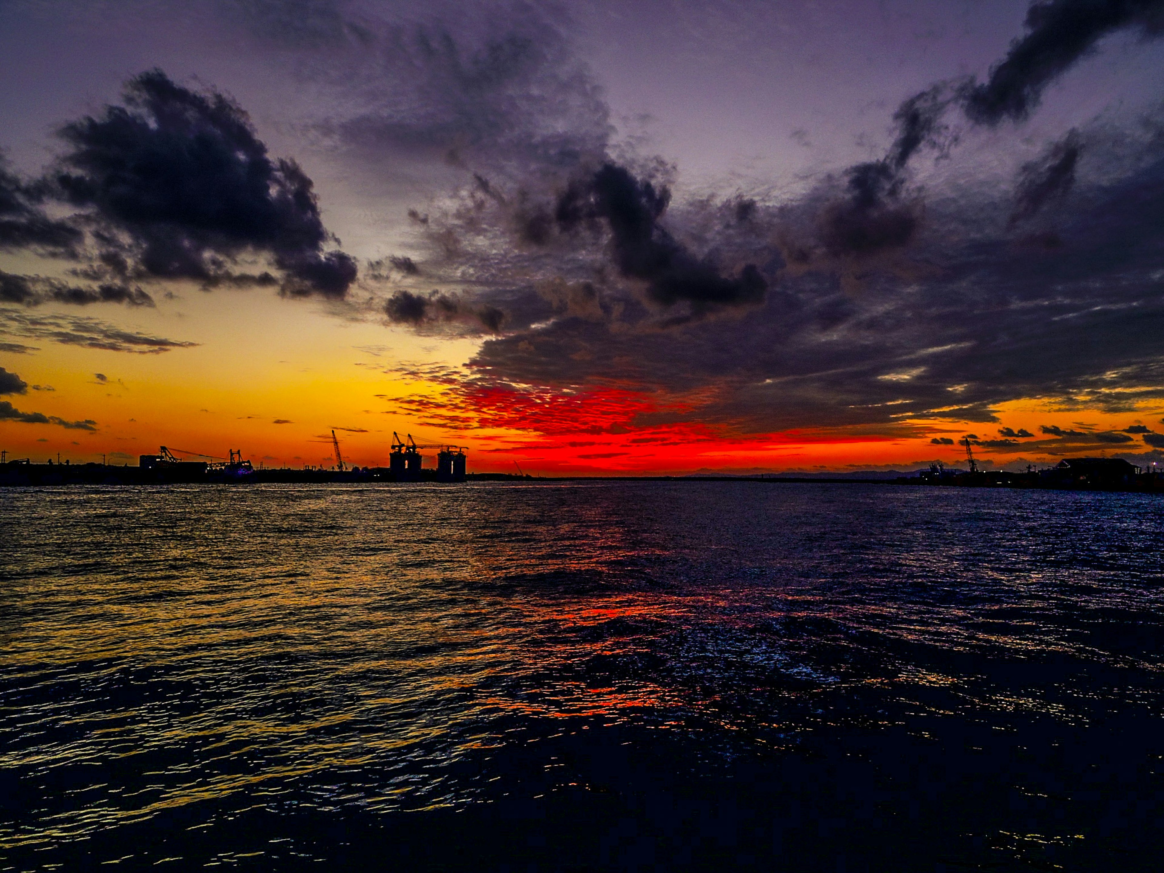 Tramonto vibrante sull'oceano con nuvole drammatiche