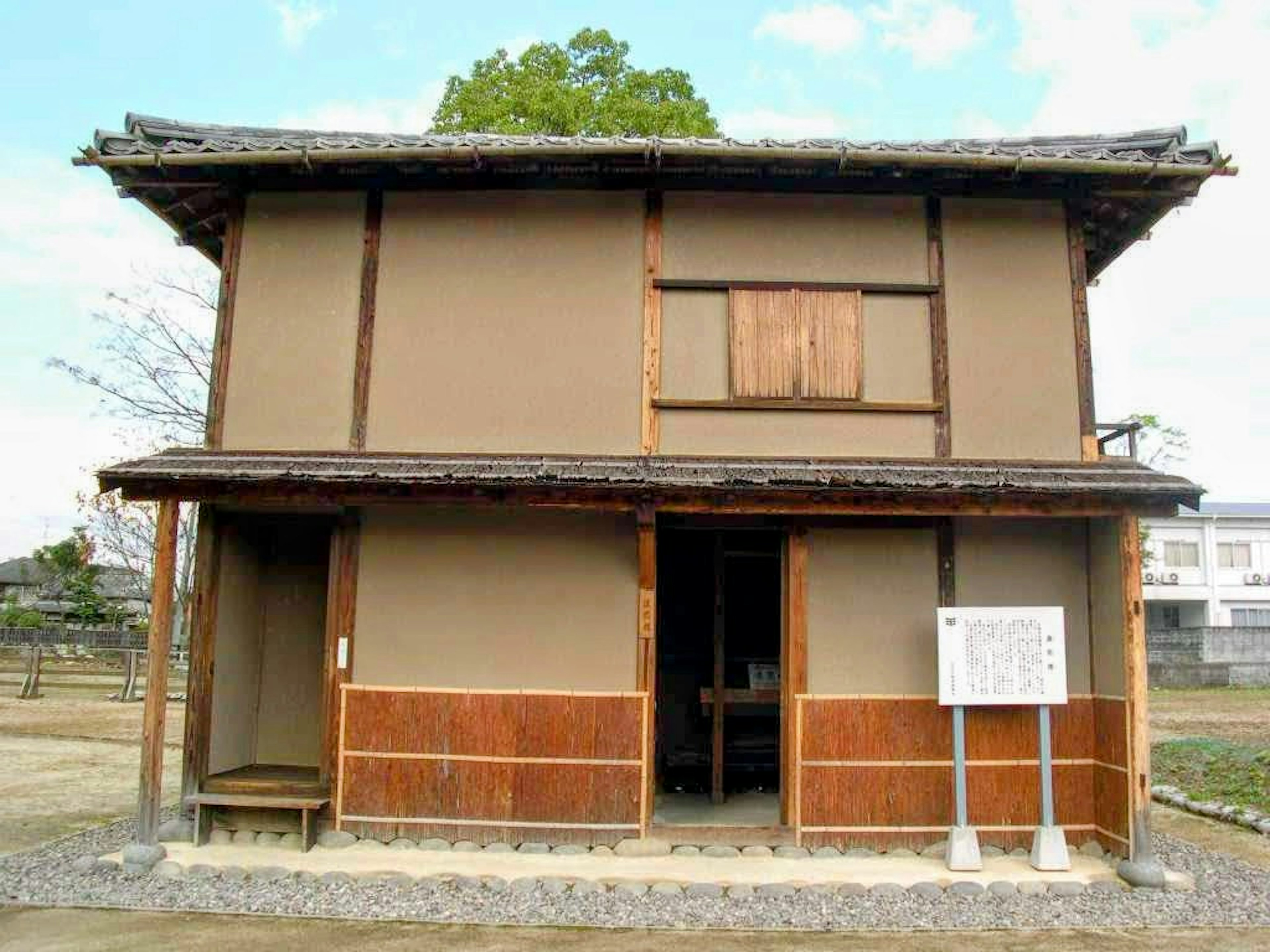 Eksterior rumah tradisional Jepang dengan struktur kayu dinding coklat atap genteng dikelilingi alam