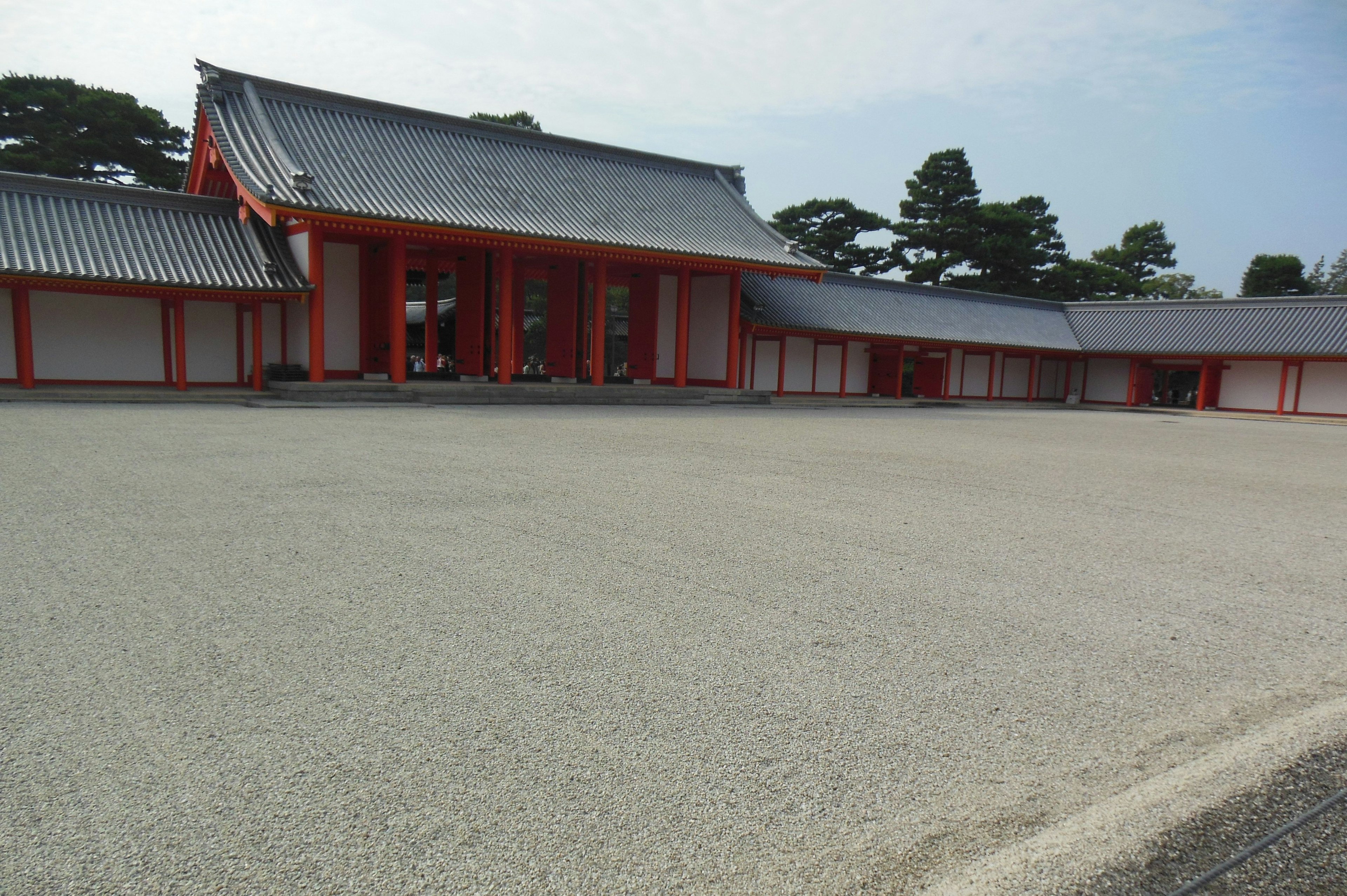 Edificio japonés tradicional con pilares rojos y un amplio patio de grava