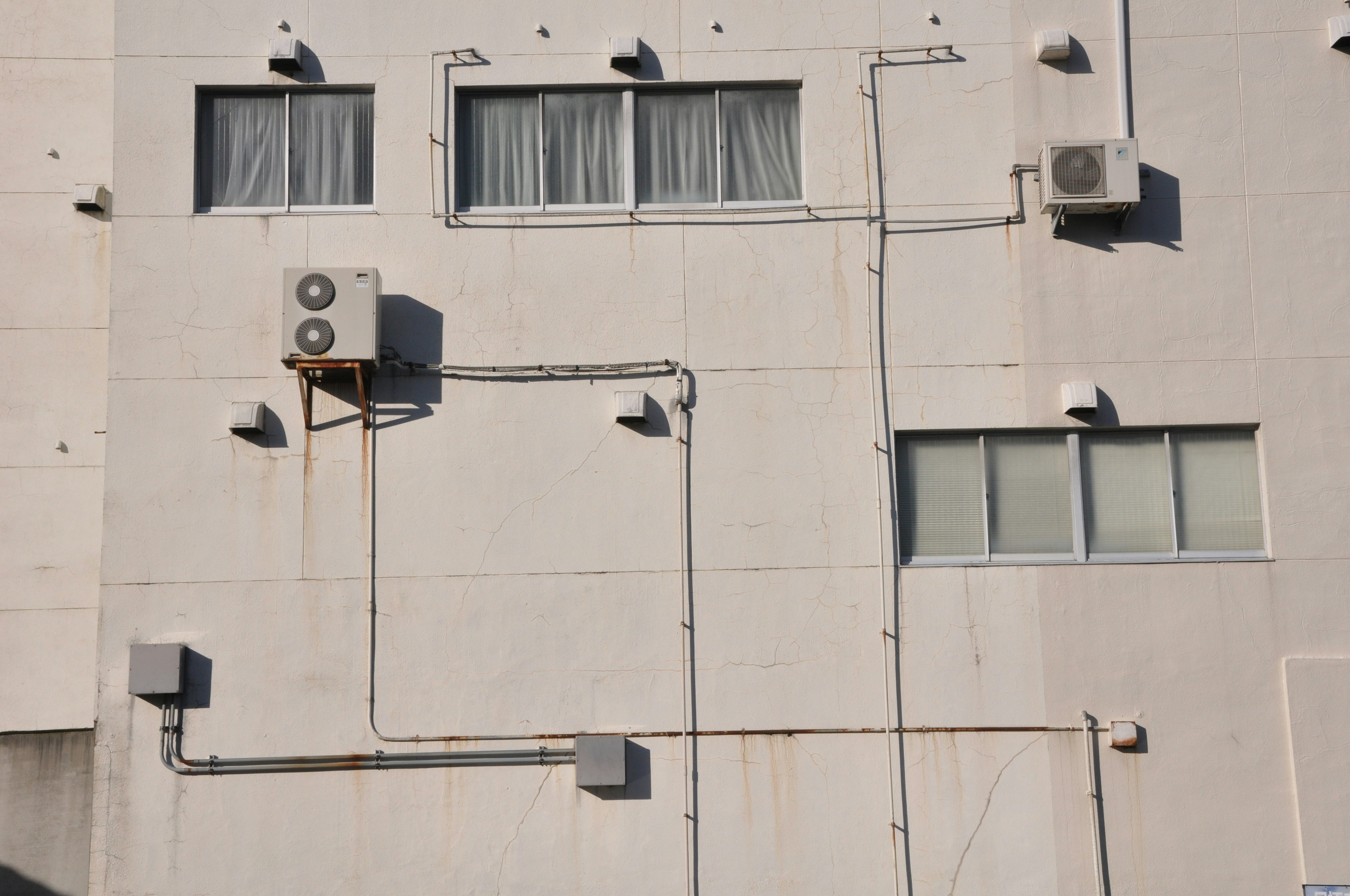 Immagine di unità di climatizzazione e tubazioni su un muro bianco