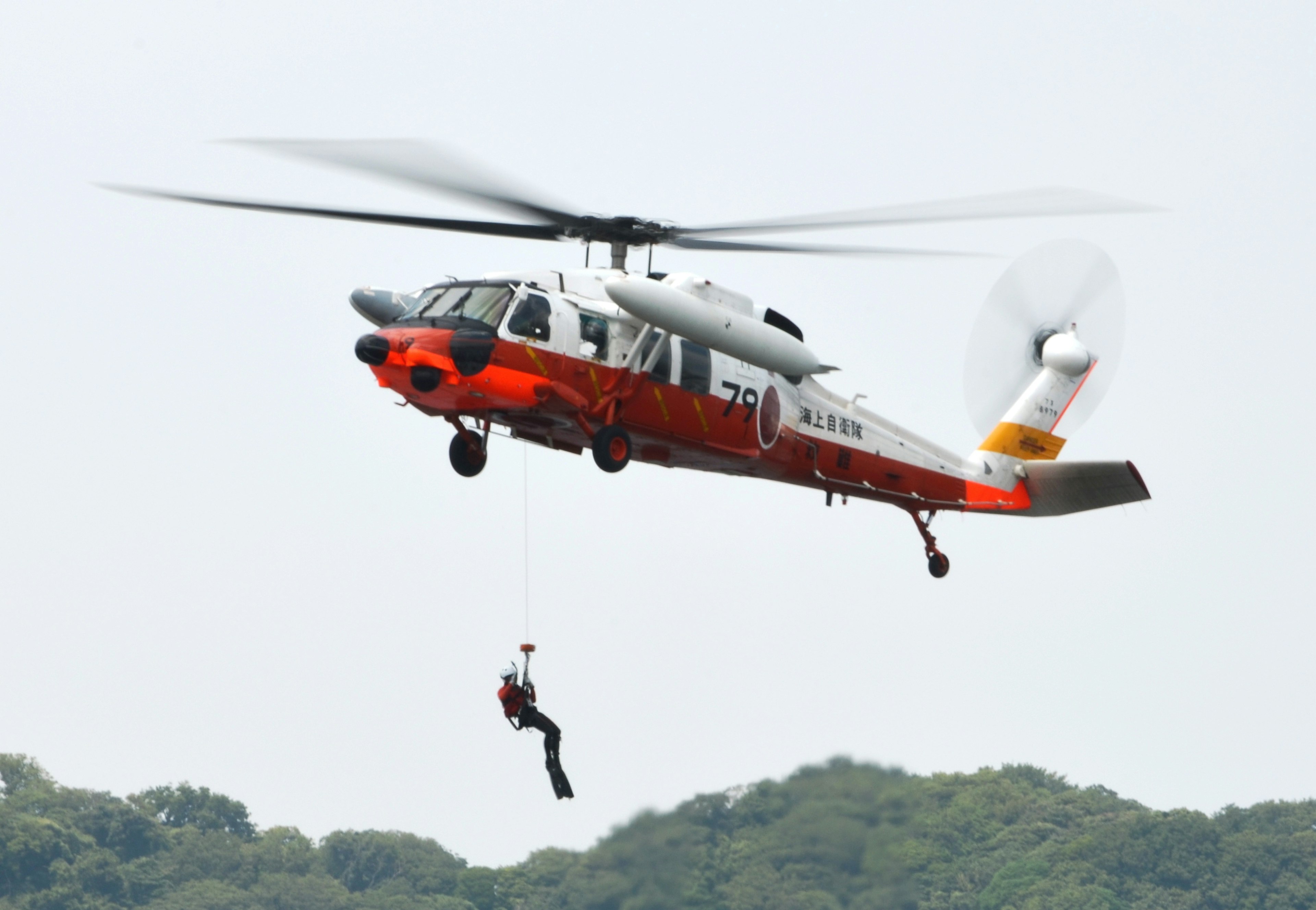 Rescue helicopter lifting a person during a mission