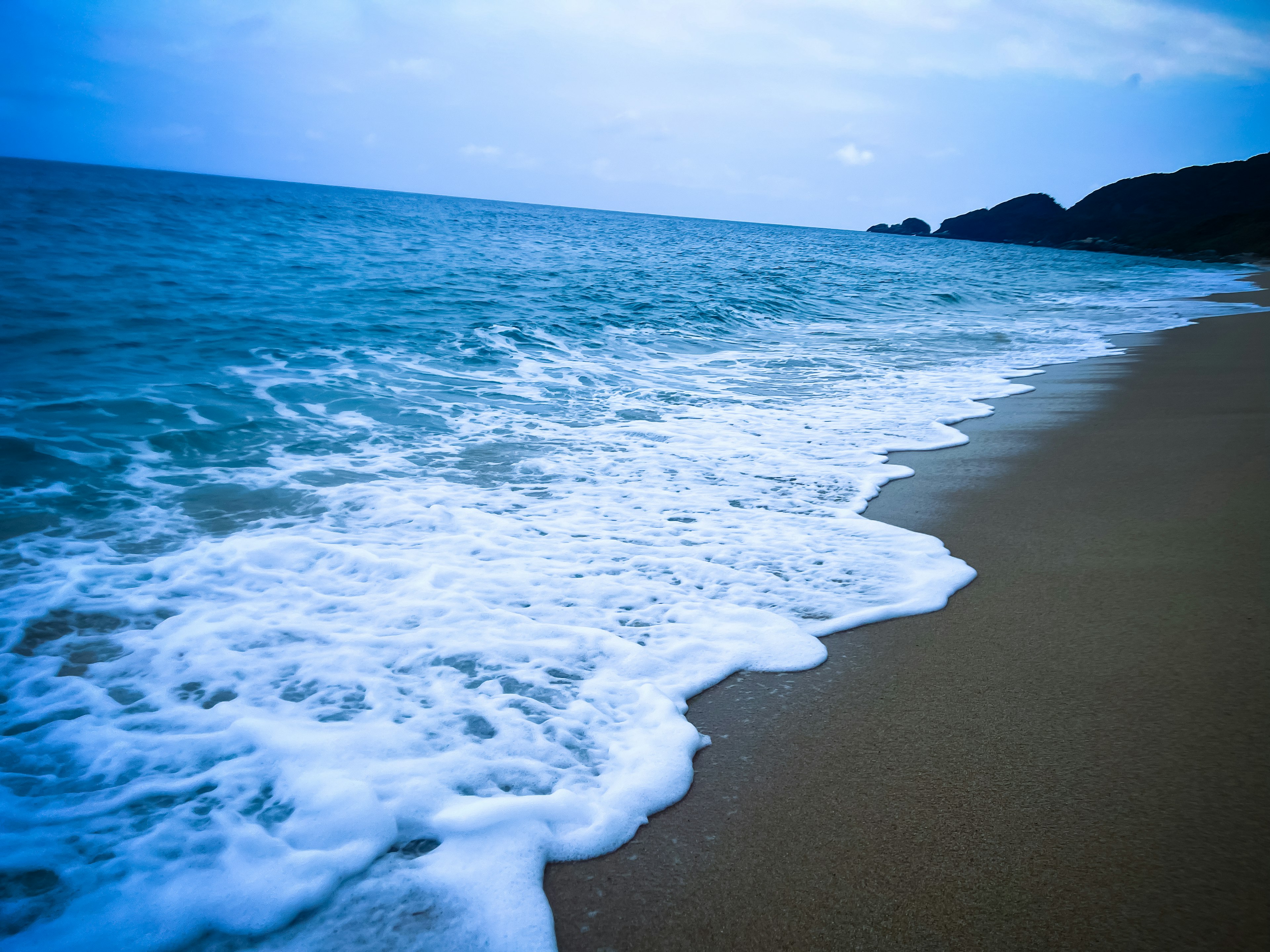 青い海と砂浜の風景波が浜辺に打ち寄せる