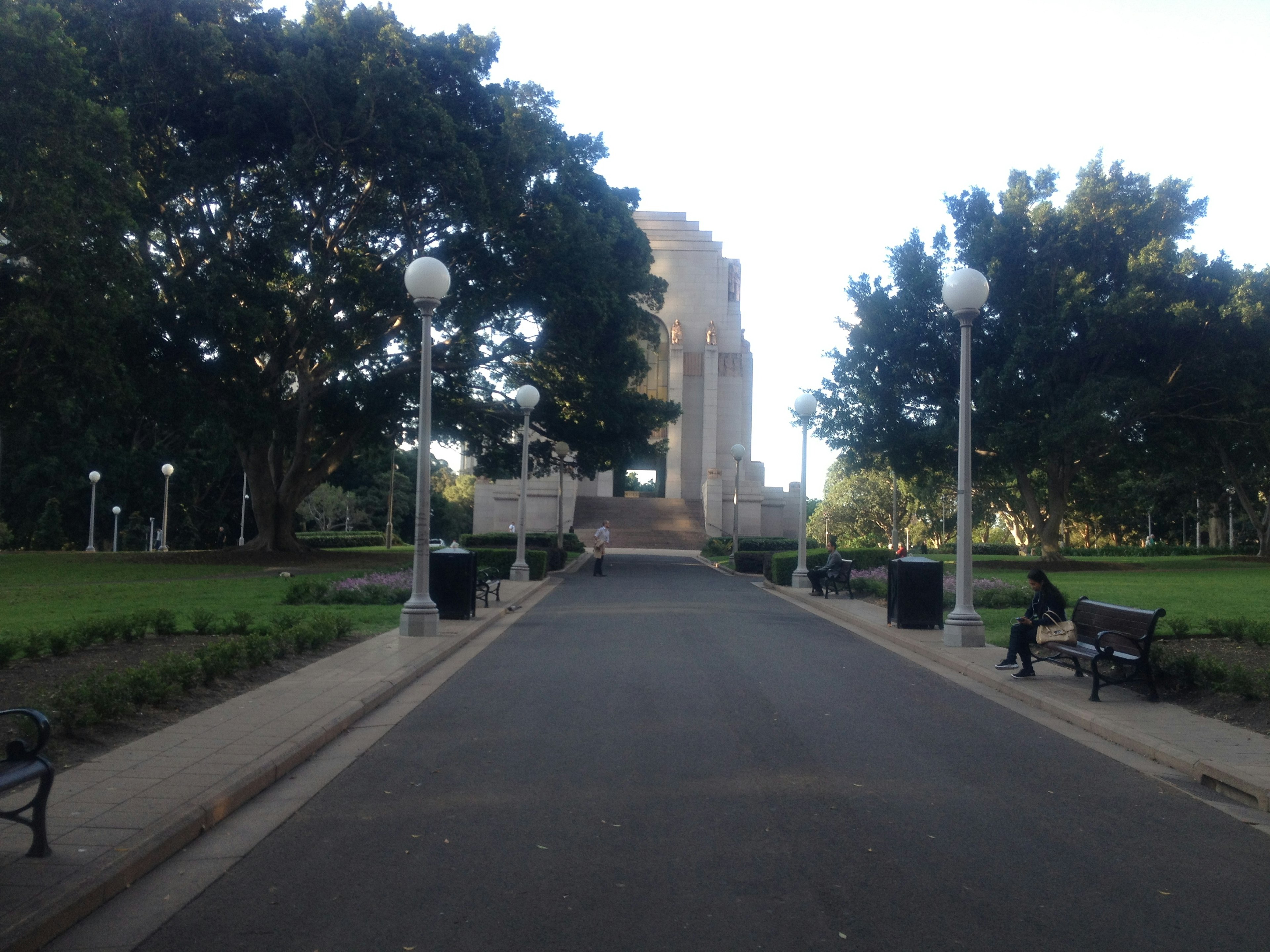 Jalan menuju monumen dikelilingi pohon dan bangku