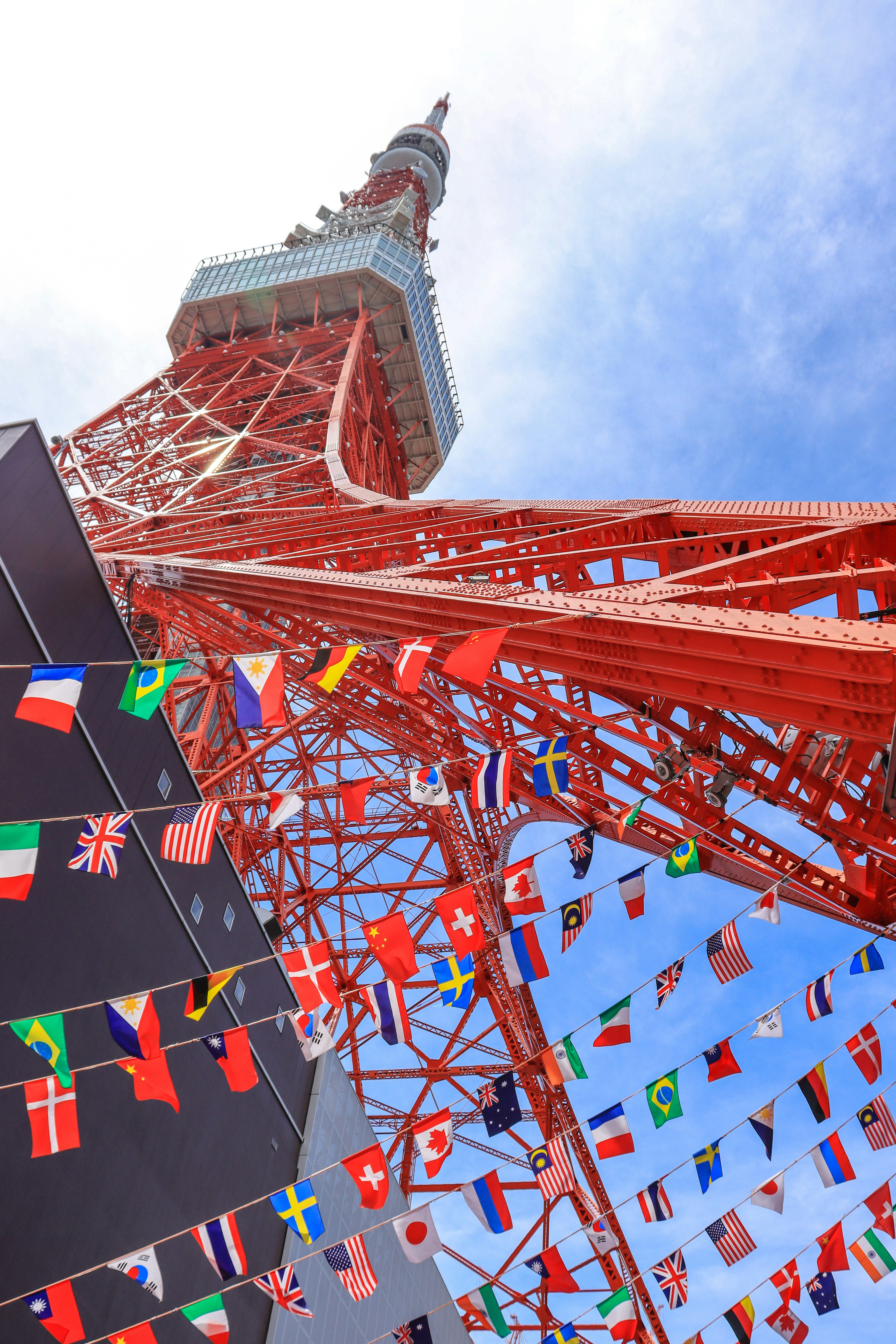 Tokio Tower mit strahlend roter Struktur und zahlreichen Fahnen