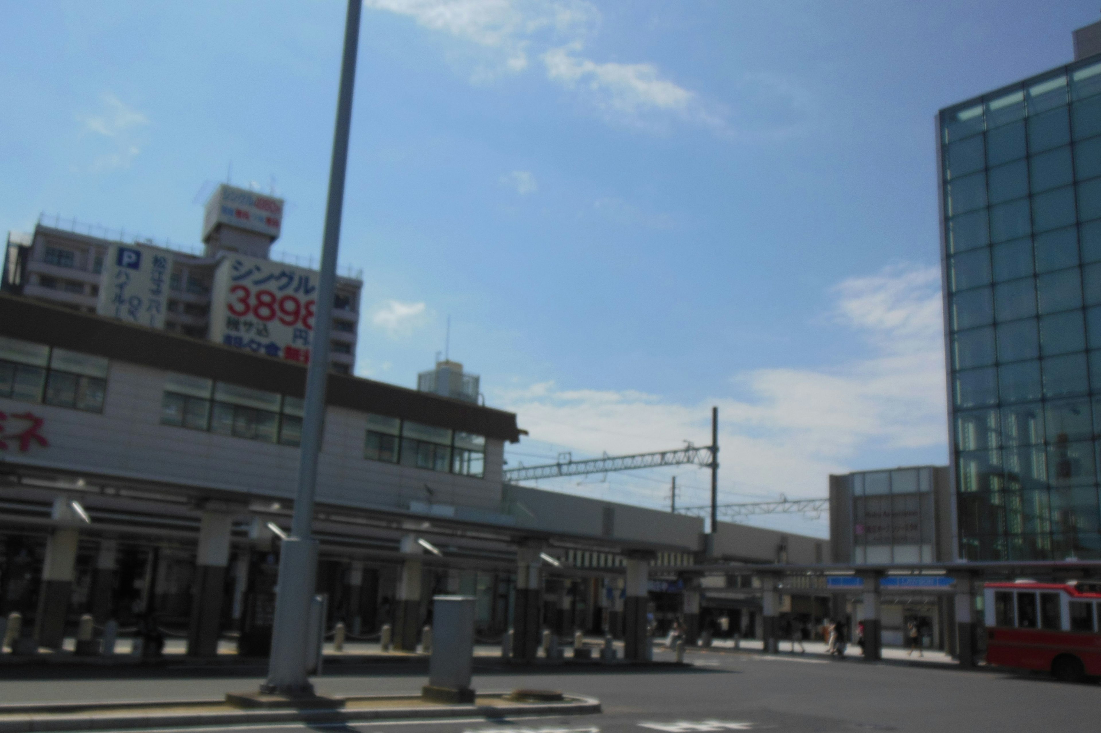 青空の下にある駅の外観と近代的なビル