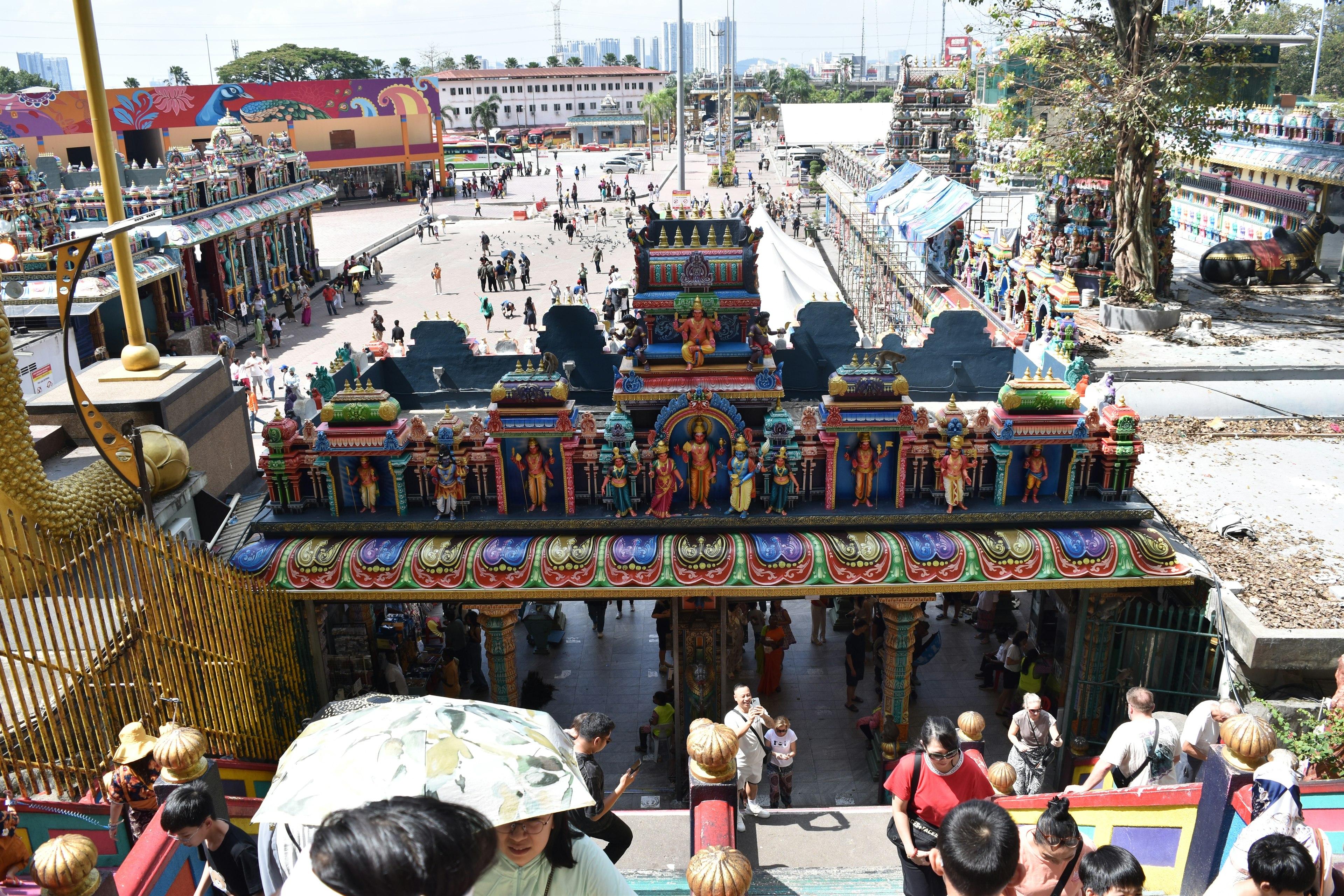 Une entrée de temple vibrante avec des décorations colorées et de nombreux visiteurs