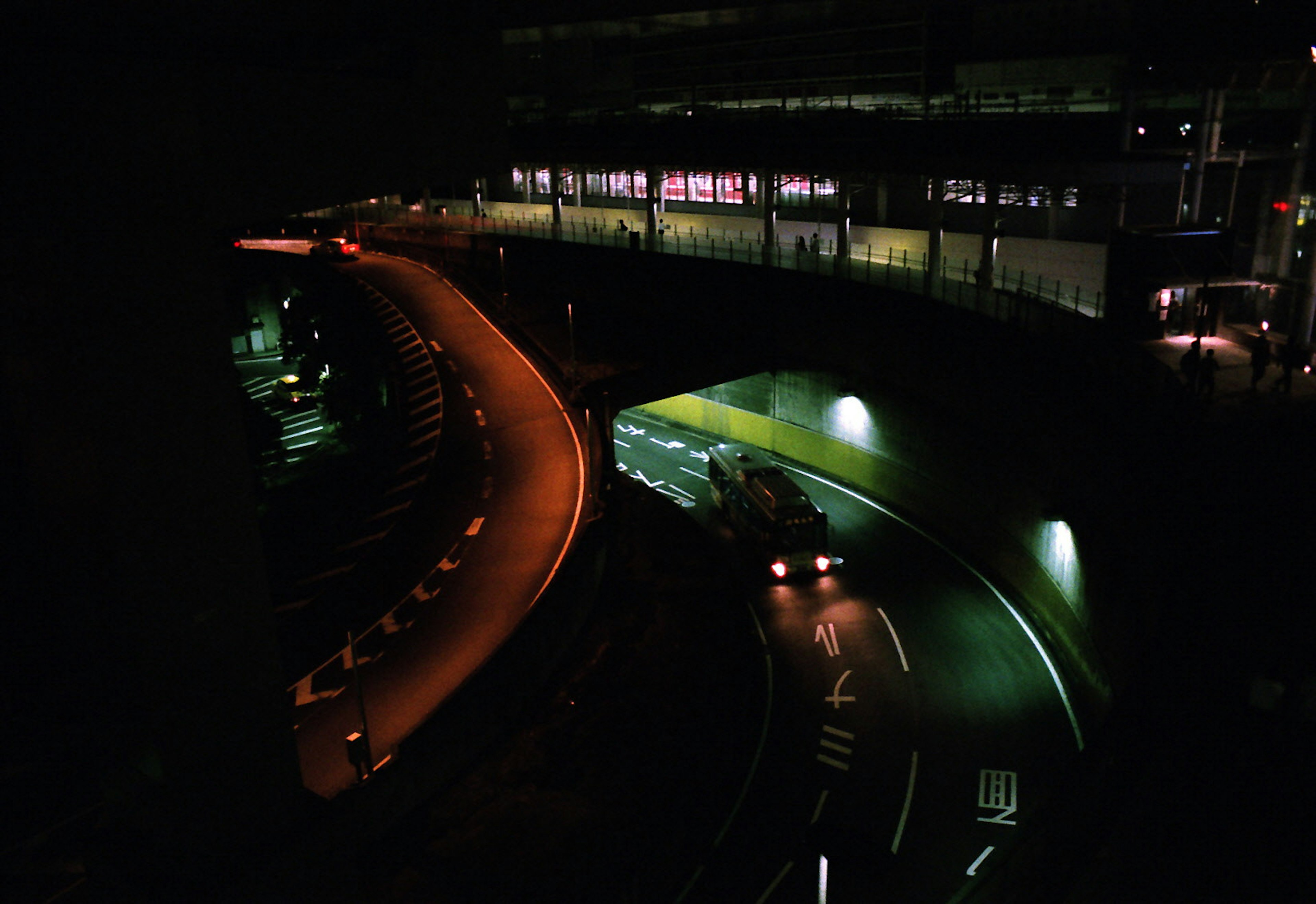 Strada curvilinea di notte con illuminazione vivace e paesaggio urbano