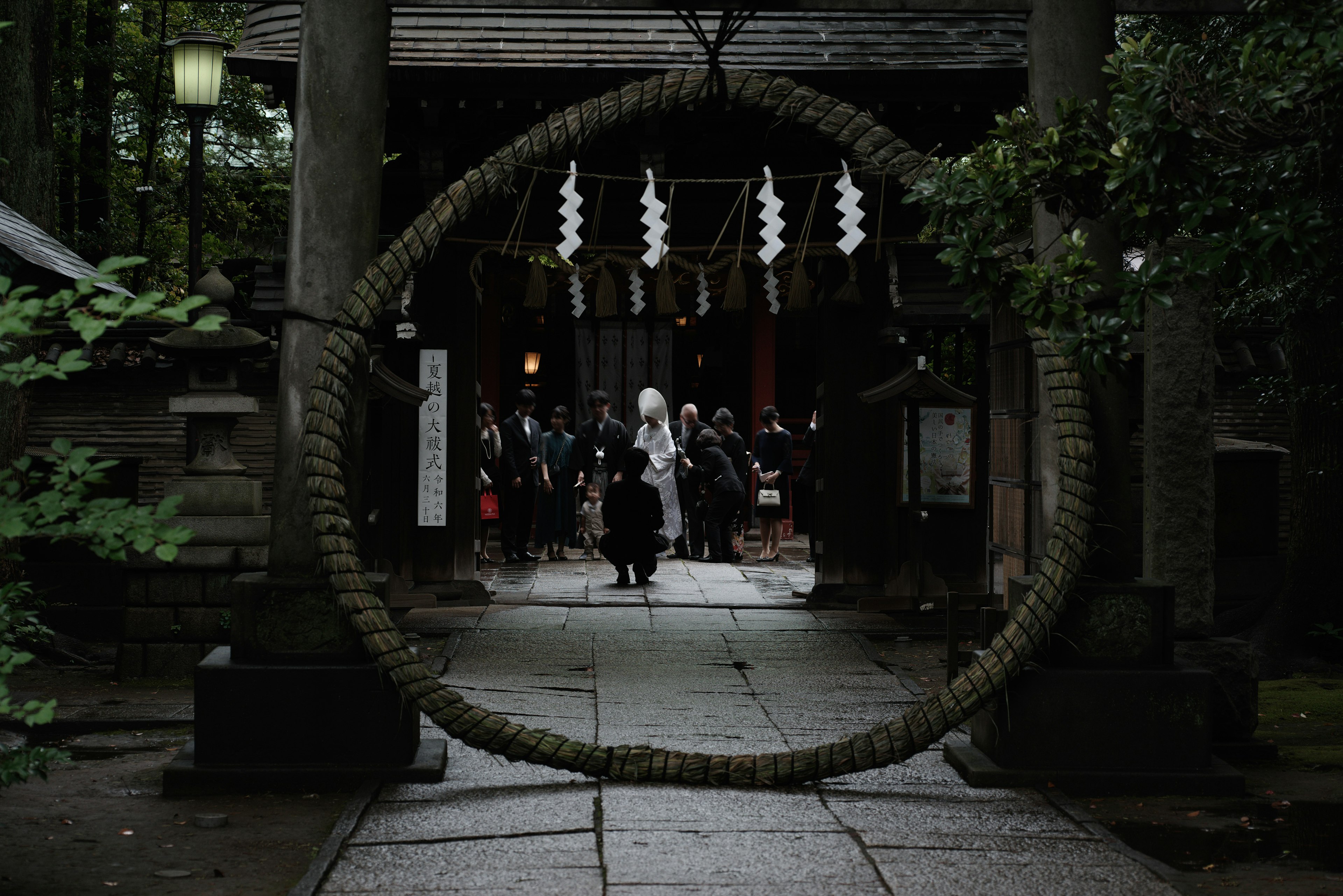 Des personnes passant par un torii de sanctuaire et un anneau sacré