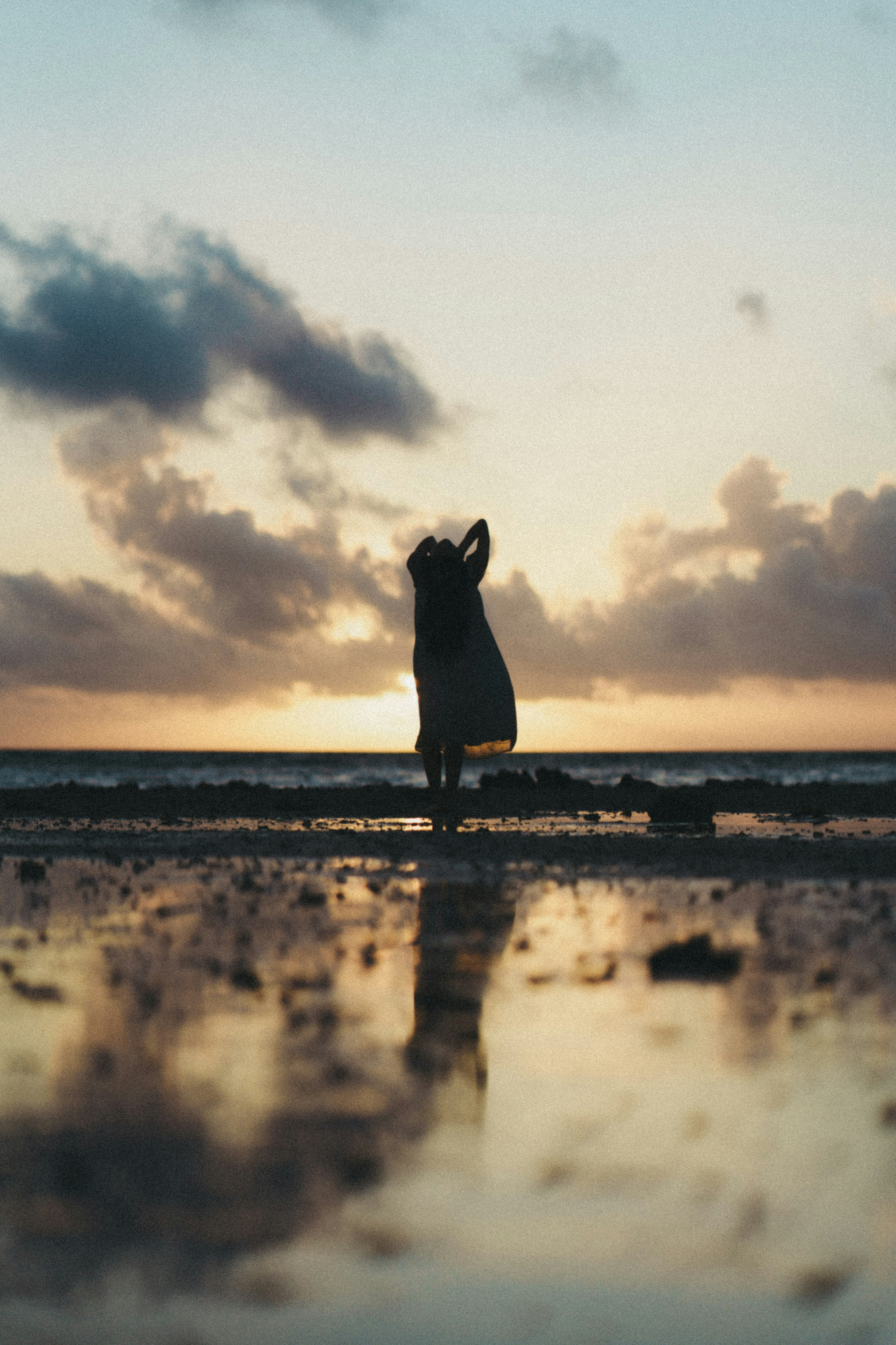 夕日を背景にした海辺でのシルエットの人物