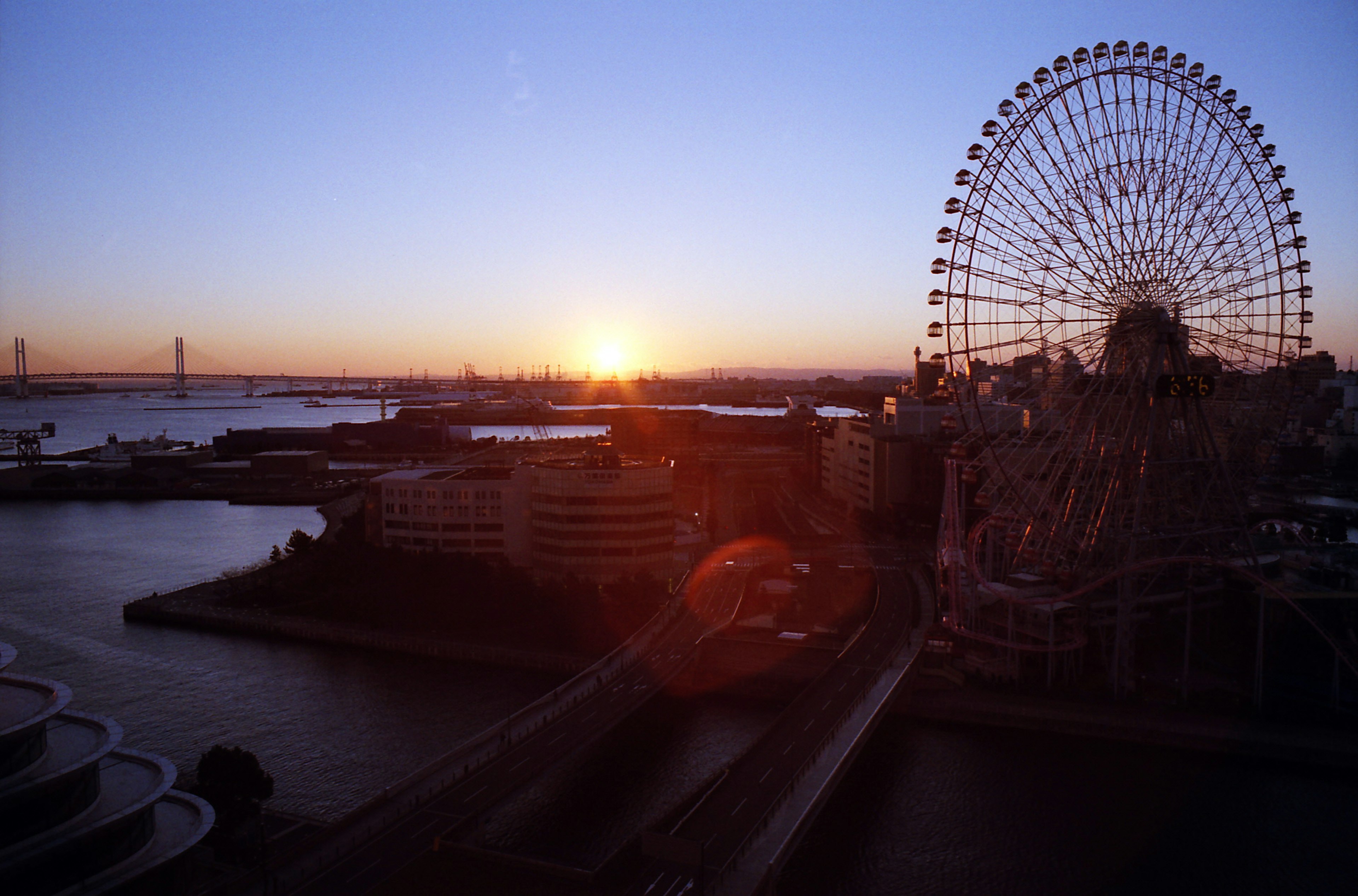 Vue de la grande roue et du port avec le coucher de soleil en arrière-plan