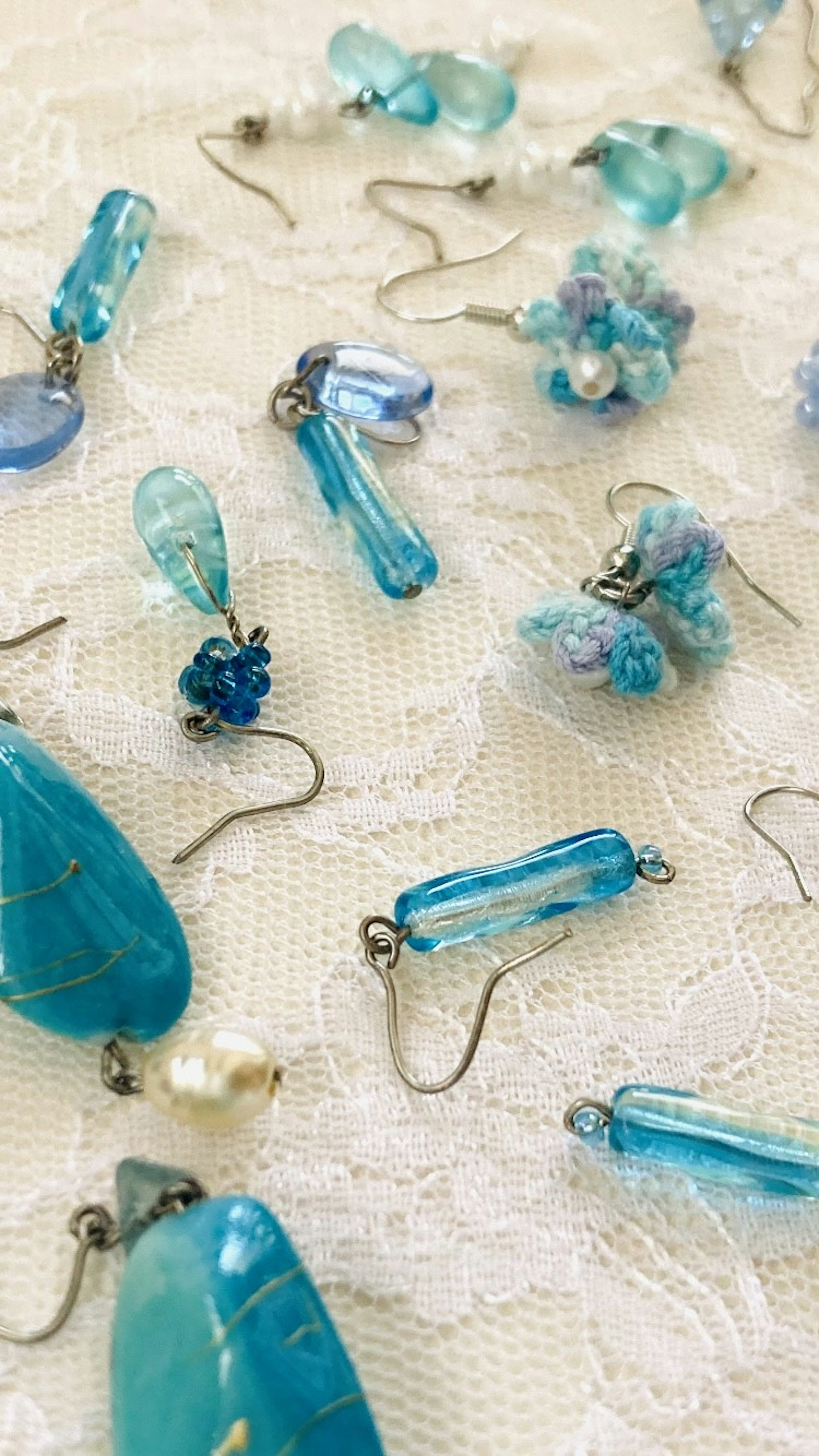 Blue beaded earrings scattered on lace fabric