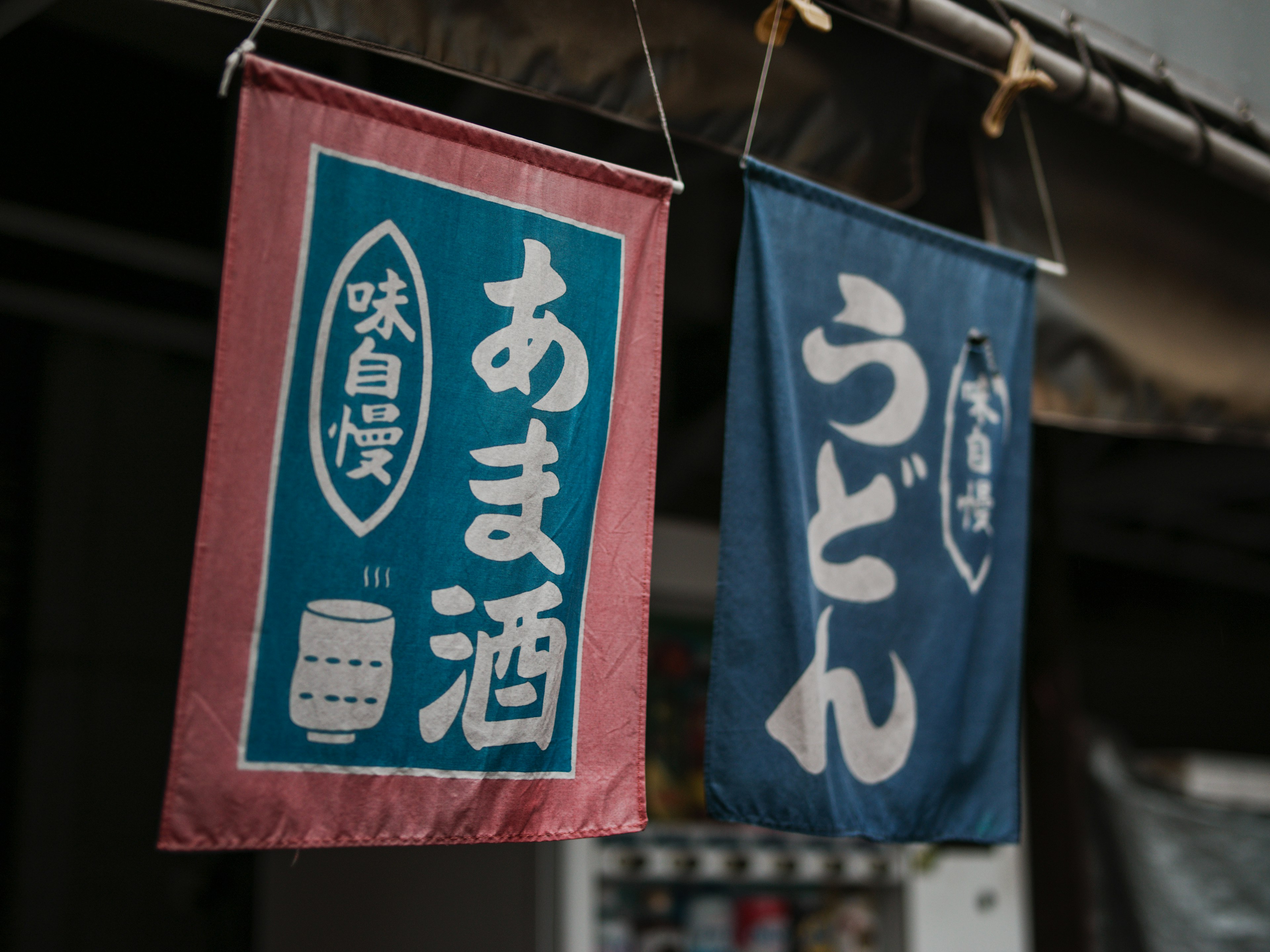 Bannières japonaises en bleu et rouge avec du texte pour le sake et les udon