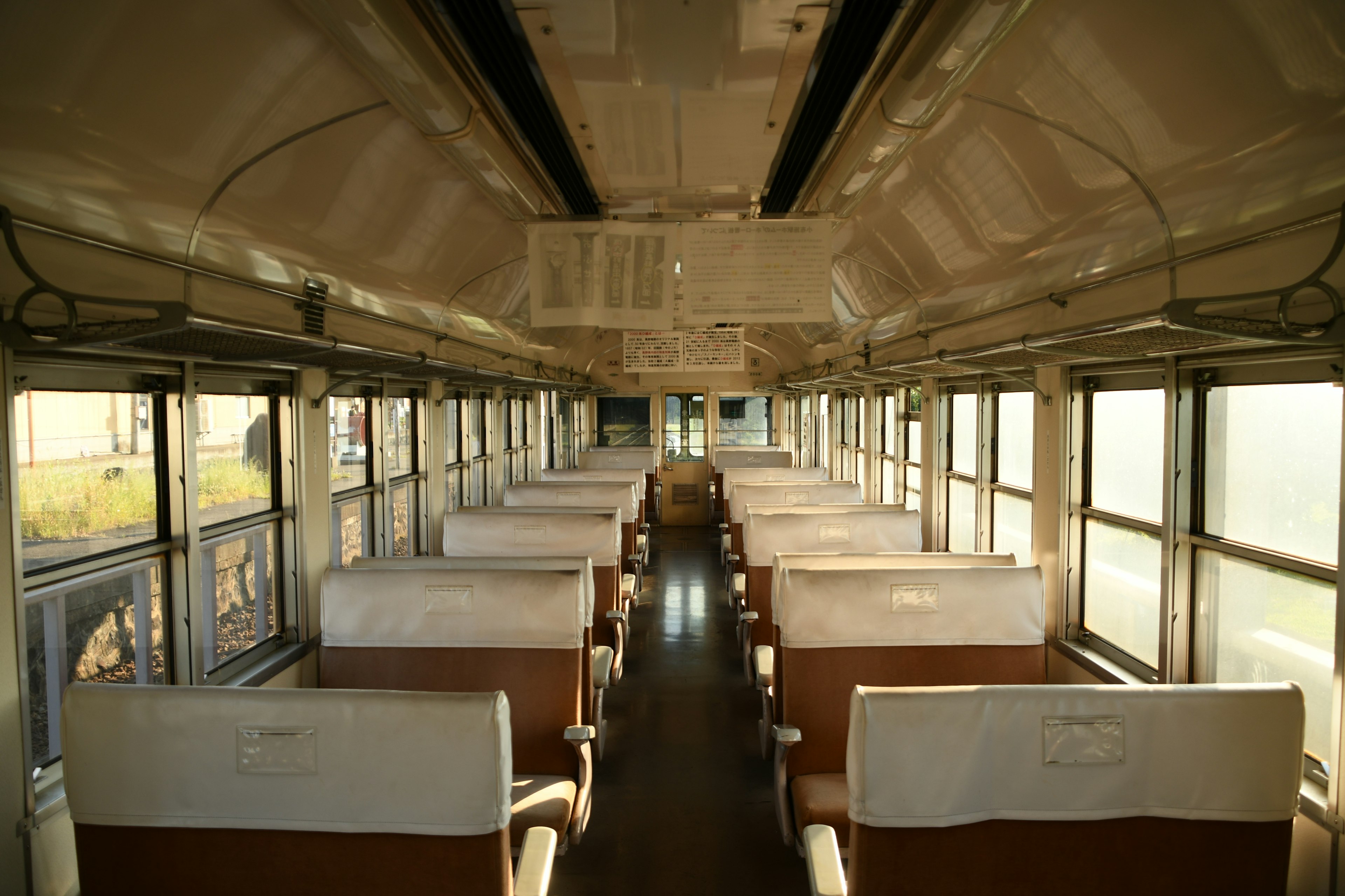 Interior of an old bus with neatly arranged seats and light streaming through the windows