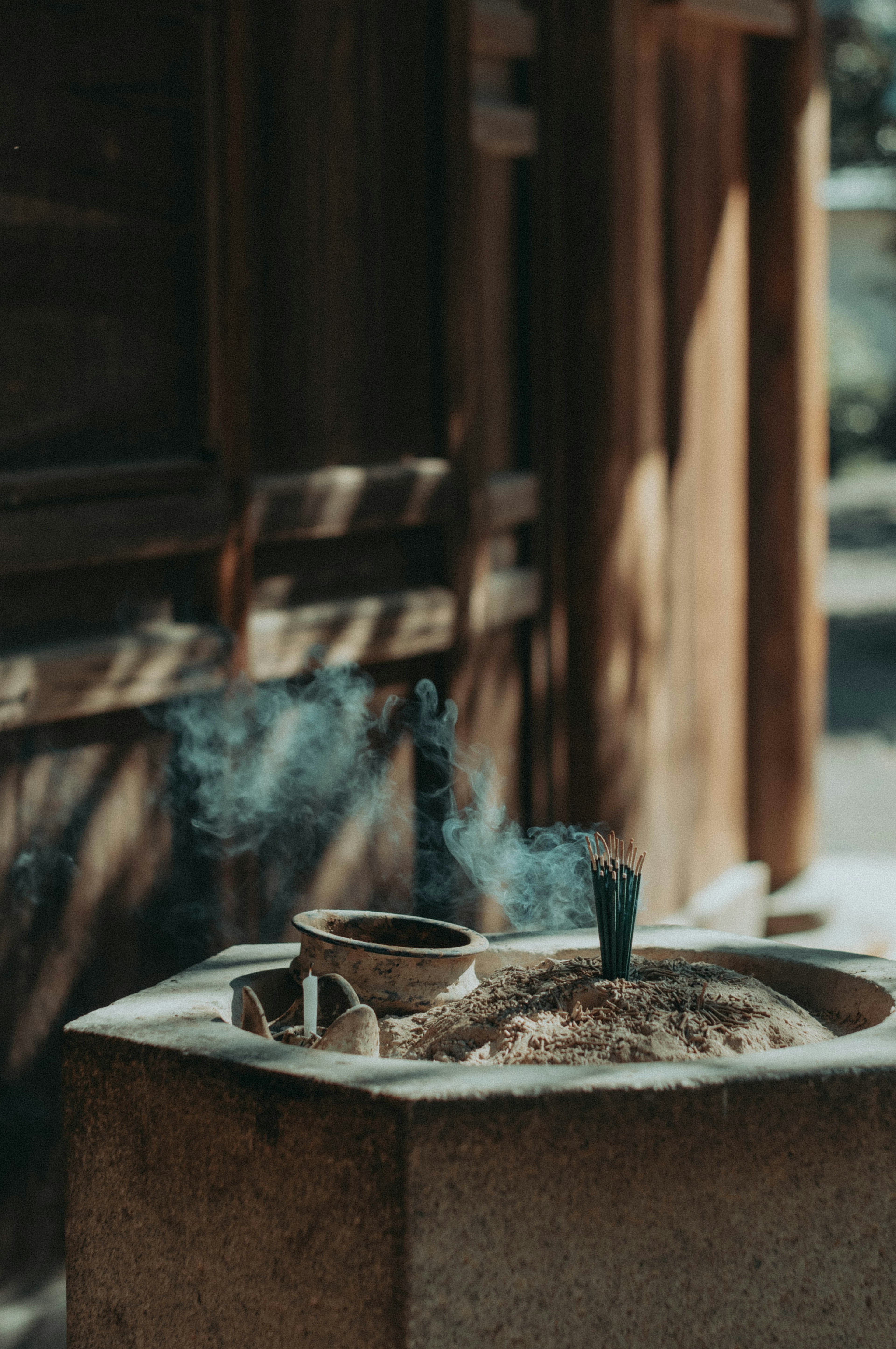 A serene scene featuring incense burning and a bowl filled with sand