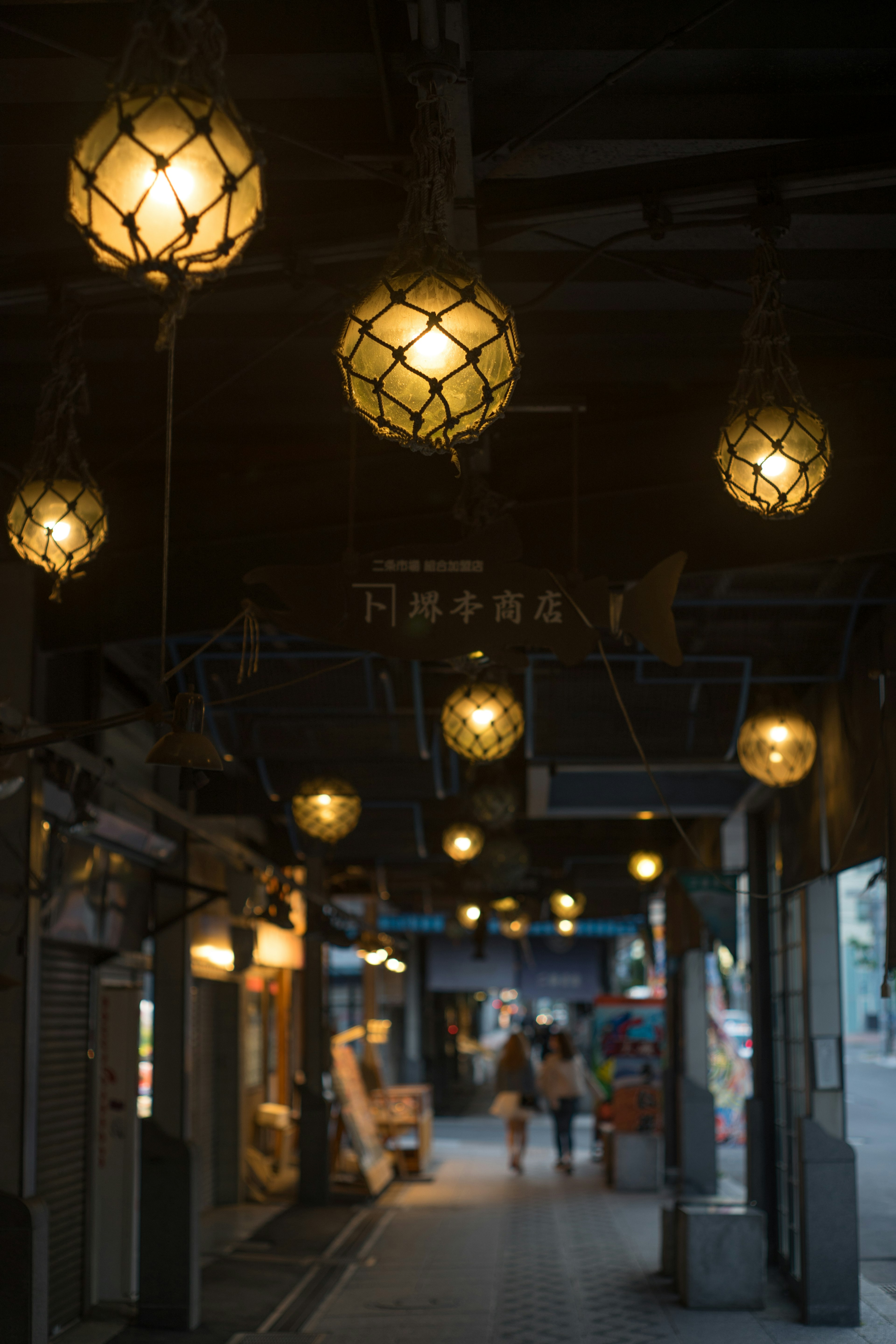 Street view with warm glowing lanterns hanging overhead