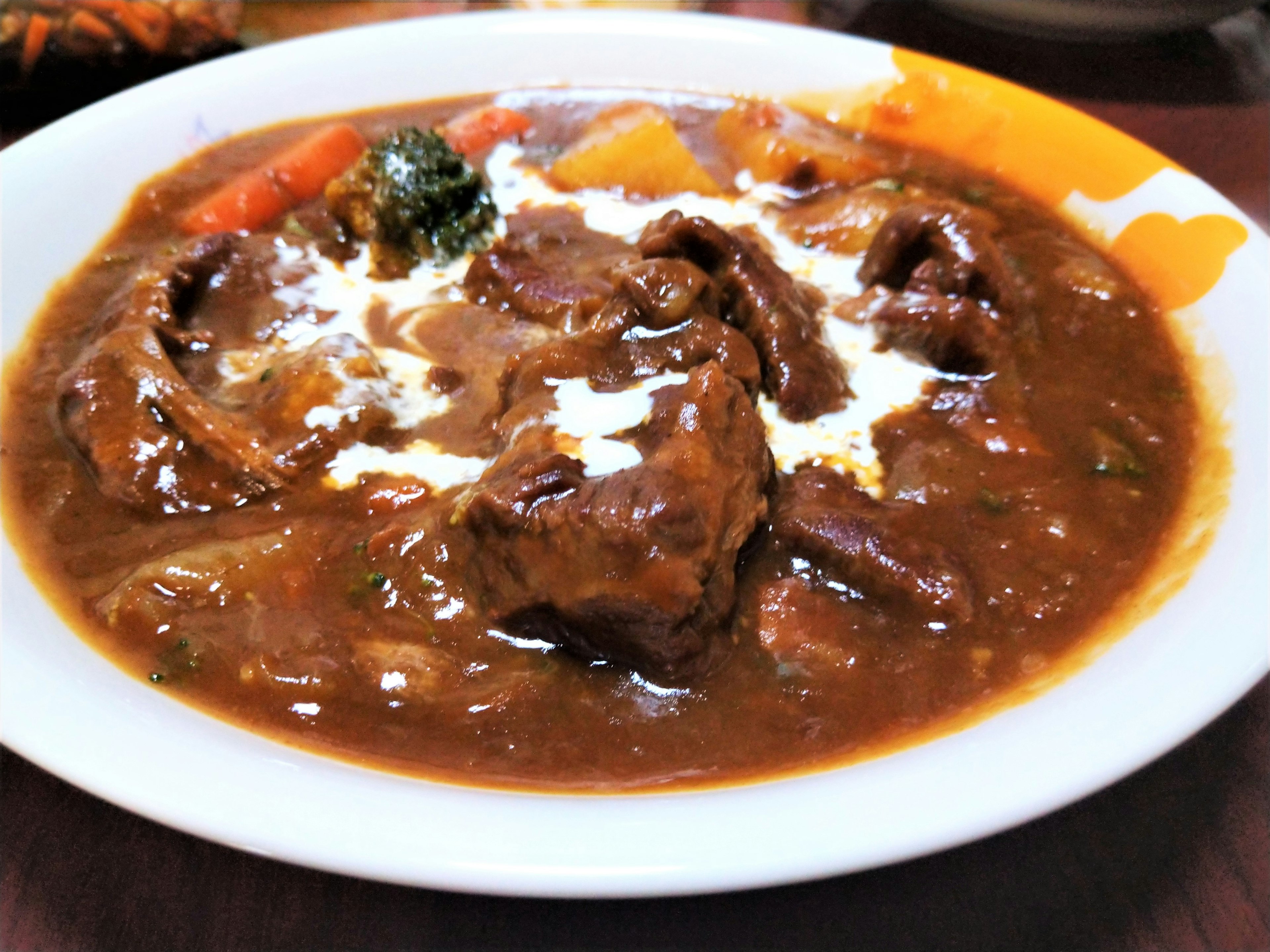 Un plato de carne abundante con salsa rica y verduras