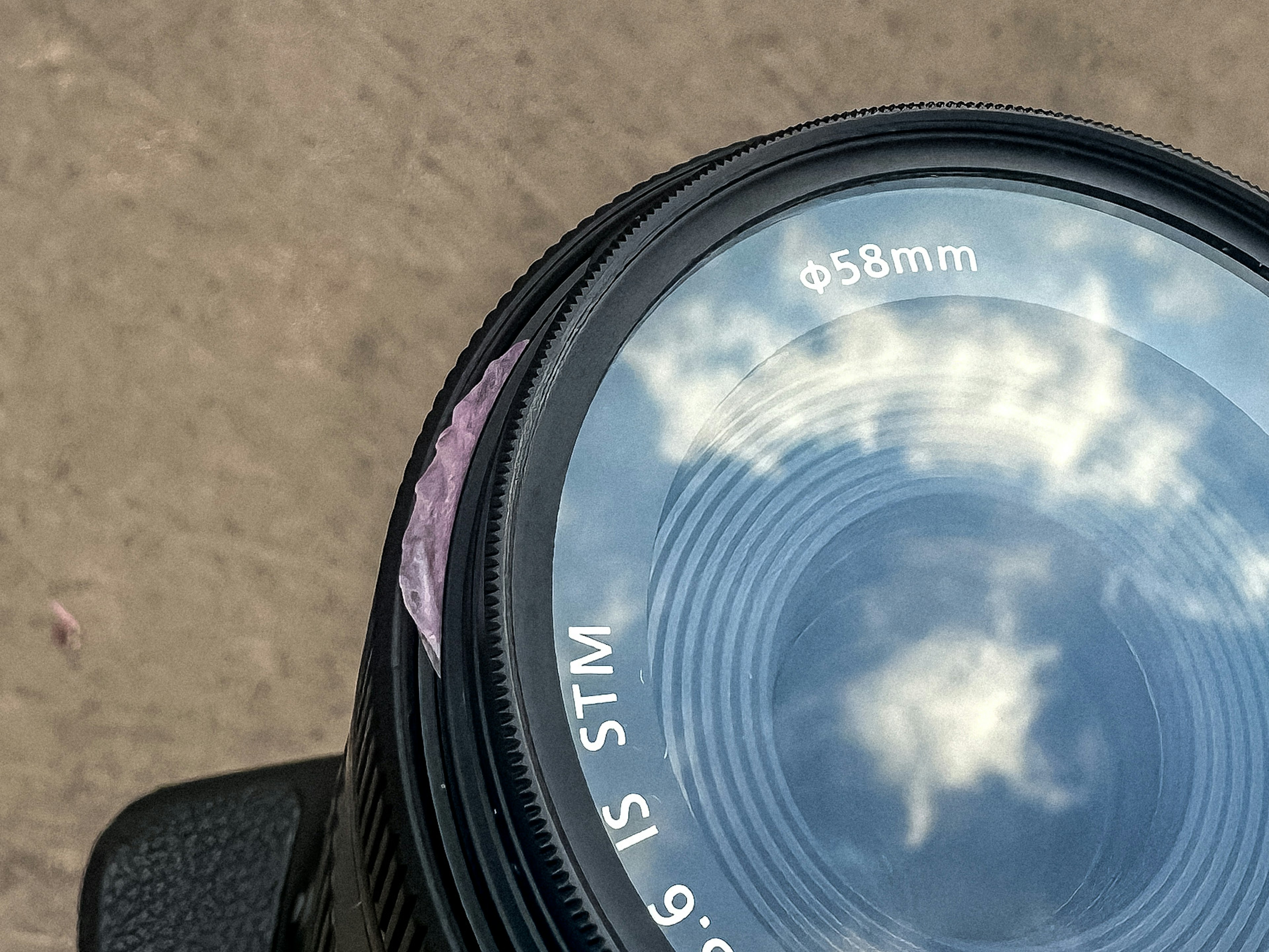 Camera lens reflecting clouds in the sky