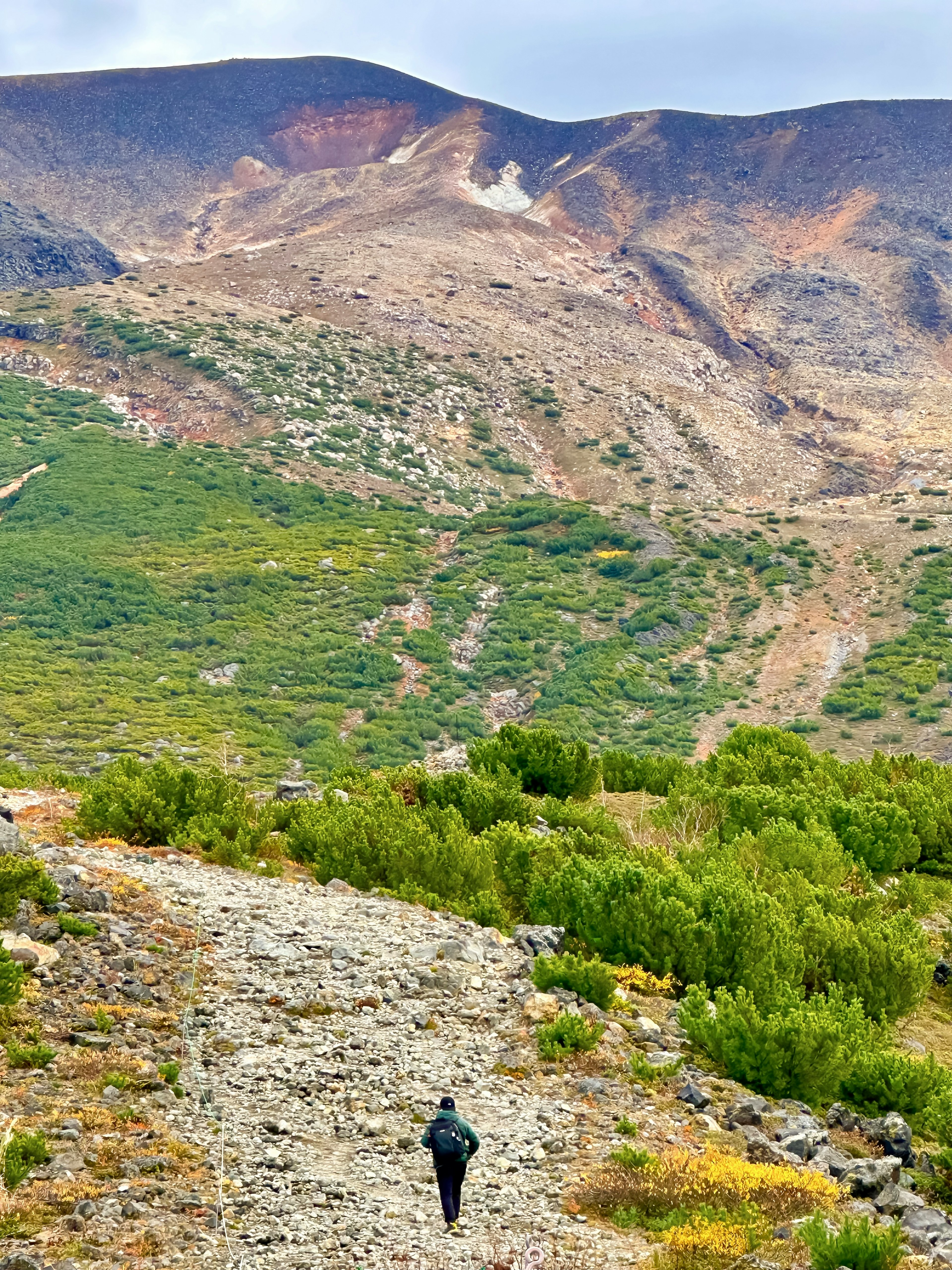 在岩石小徑上行走的人與山地風景