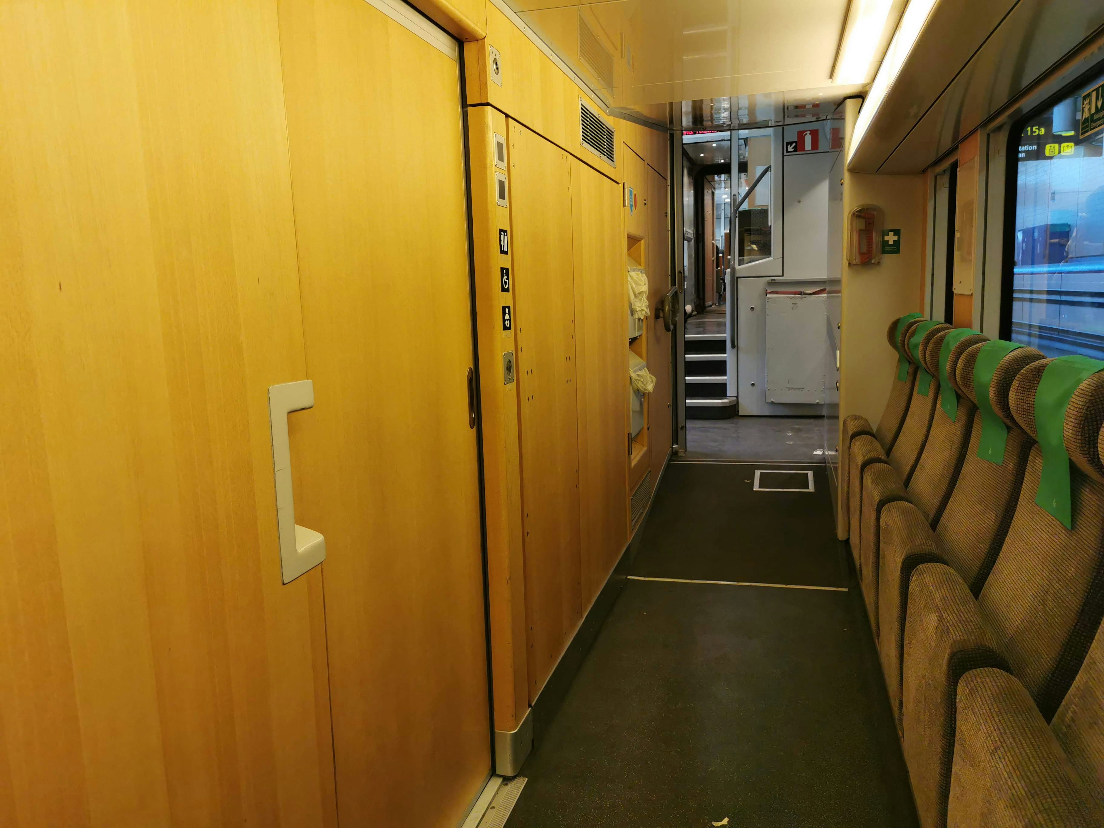 Interior de un vagón de tren con paredes de madera y asientos