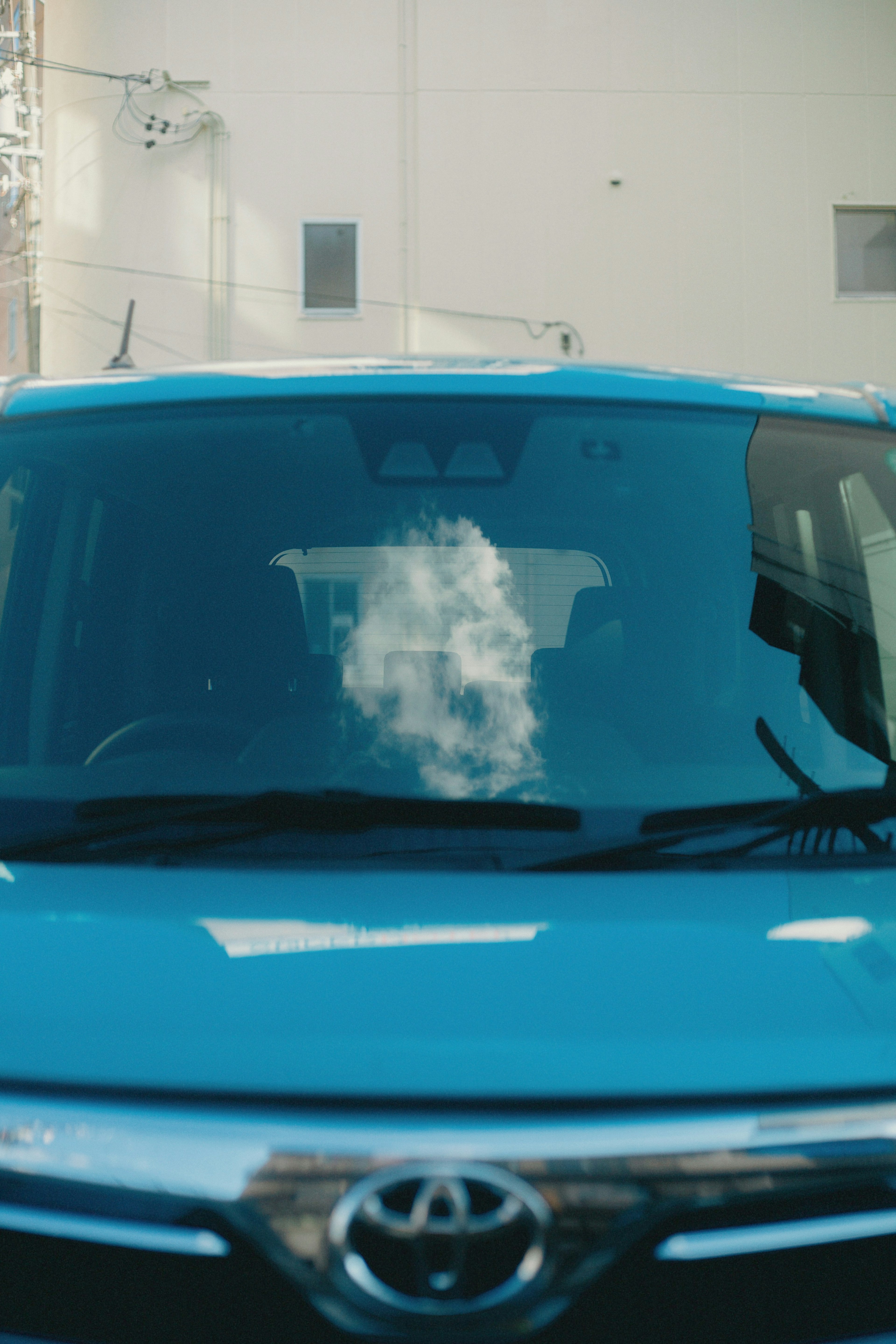 Coche Toyota azul con un reflejo de nube en el parabrisas