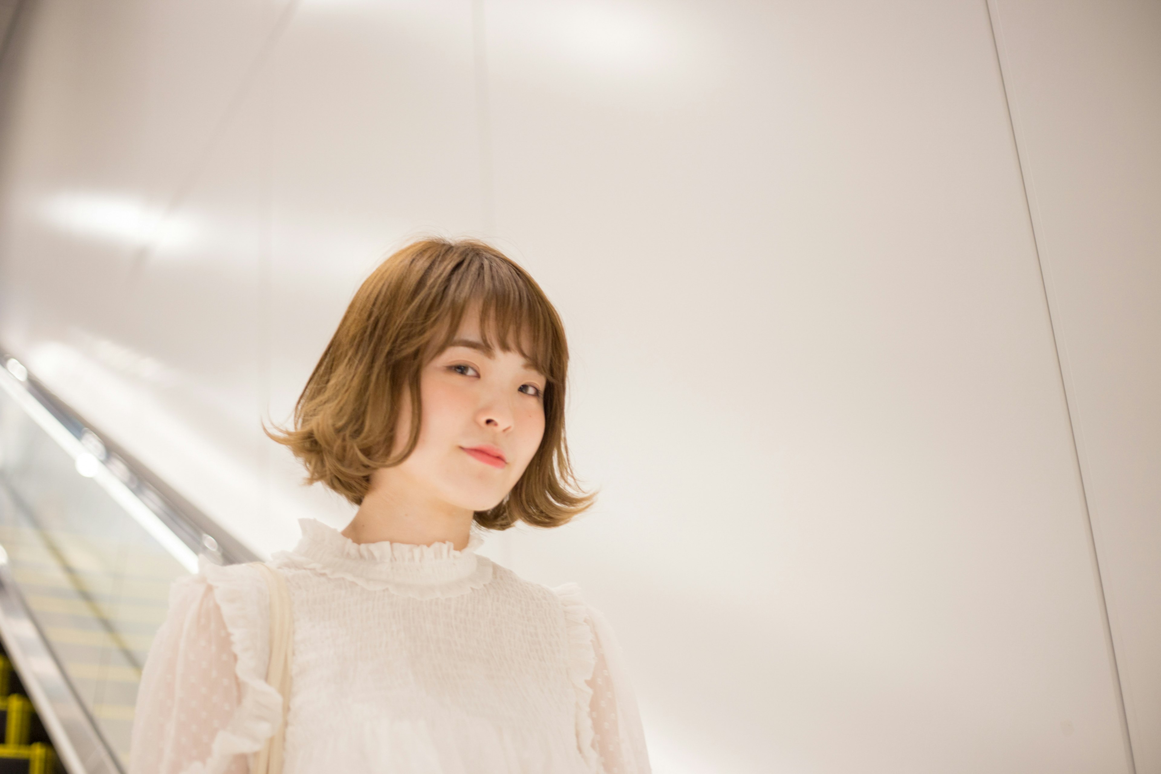 Portrait of a woman with short hair standing in front of a white wall