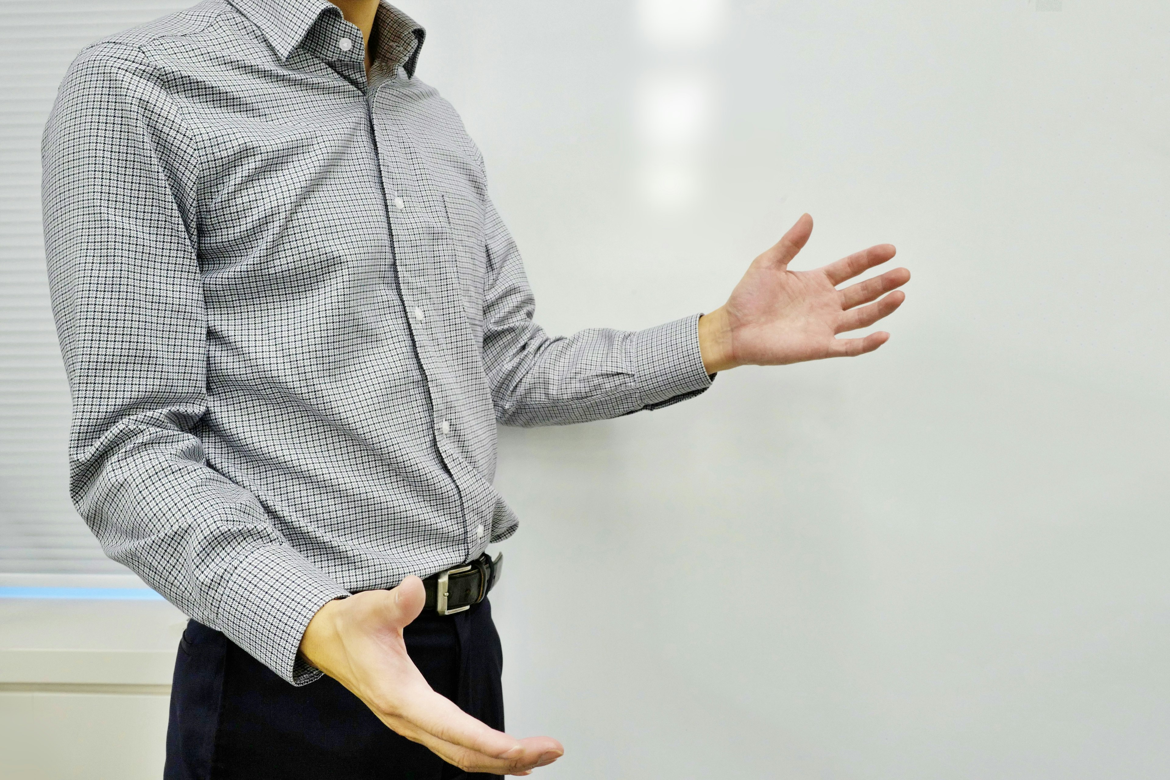 Un uomo in camicia con le mani aperte che gesticola