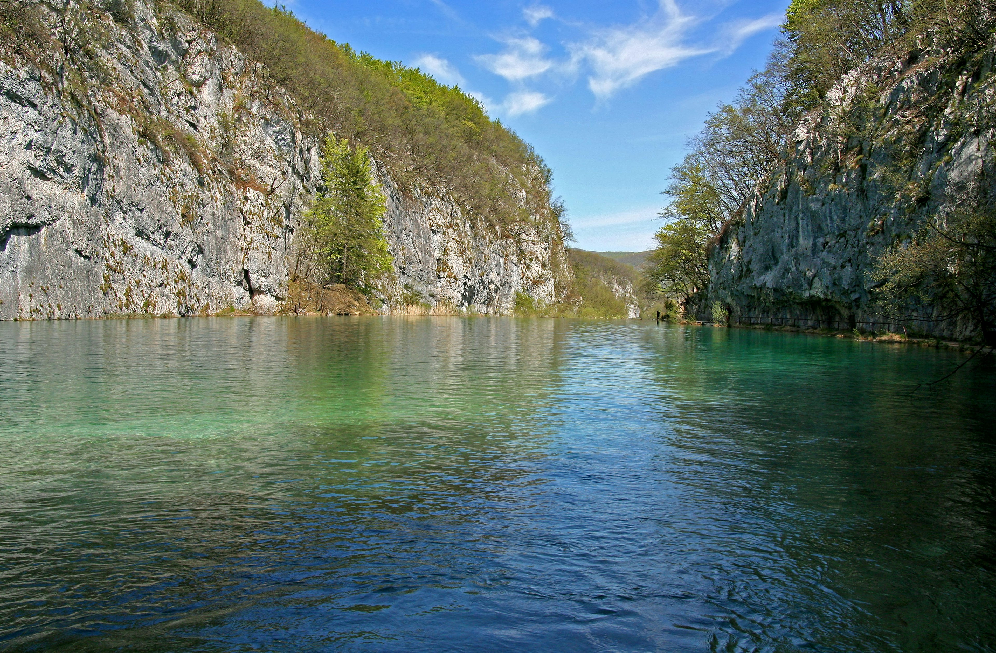 Ein ruhiger Fluss, umgeben von felsigen Klippen und üppigem Grün