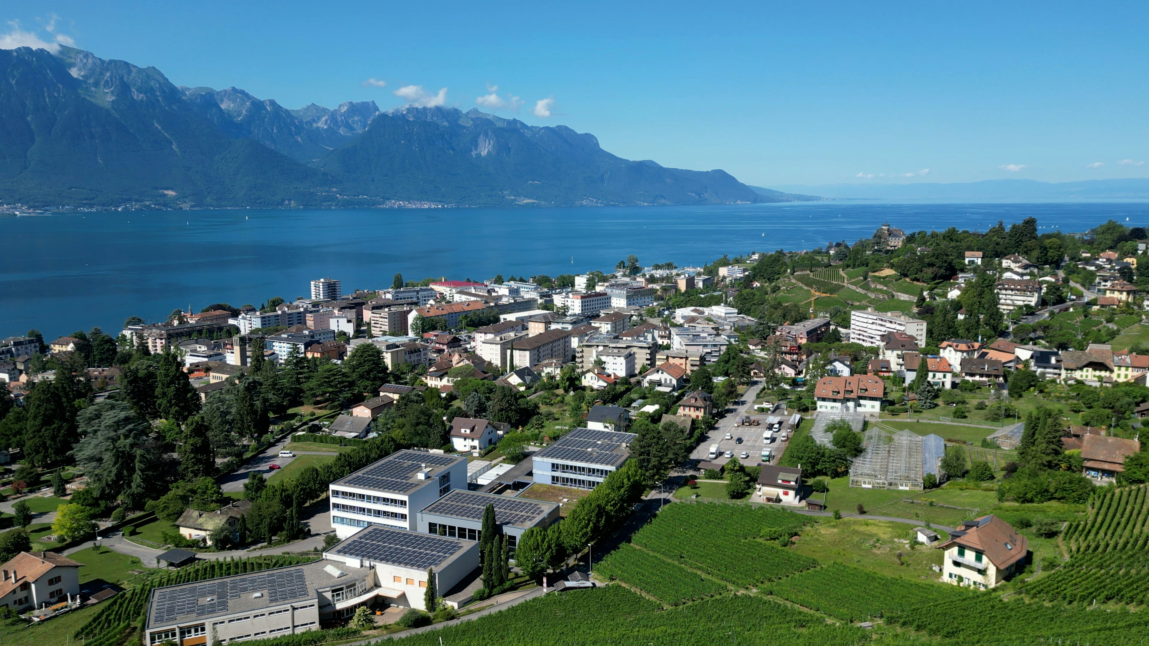 Aerial view of a town surrounded by a beautiful lake and mountains