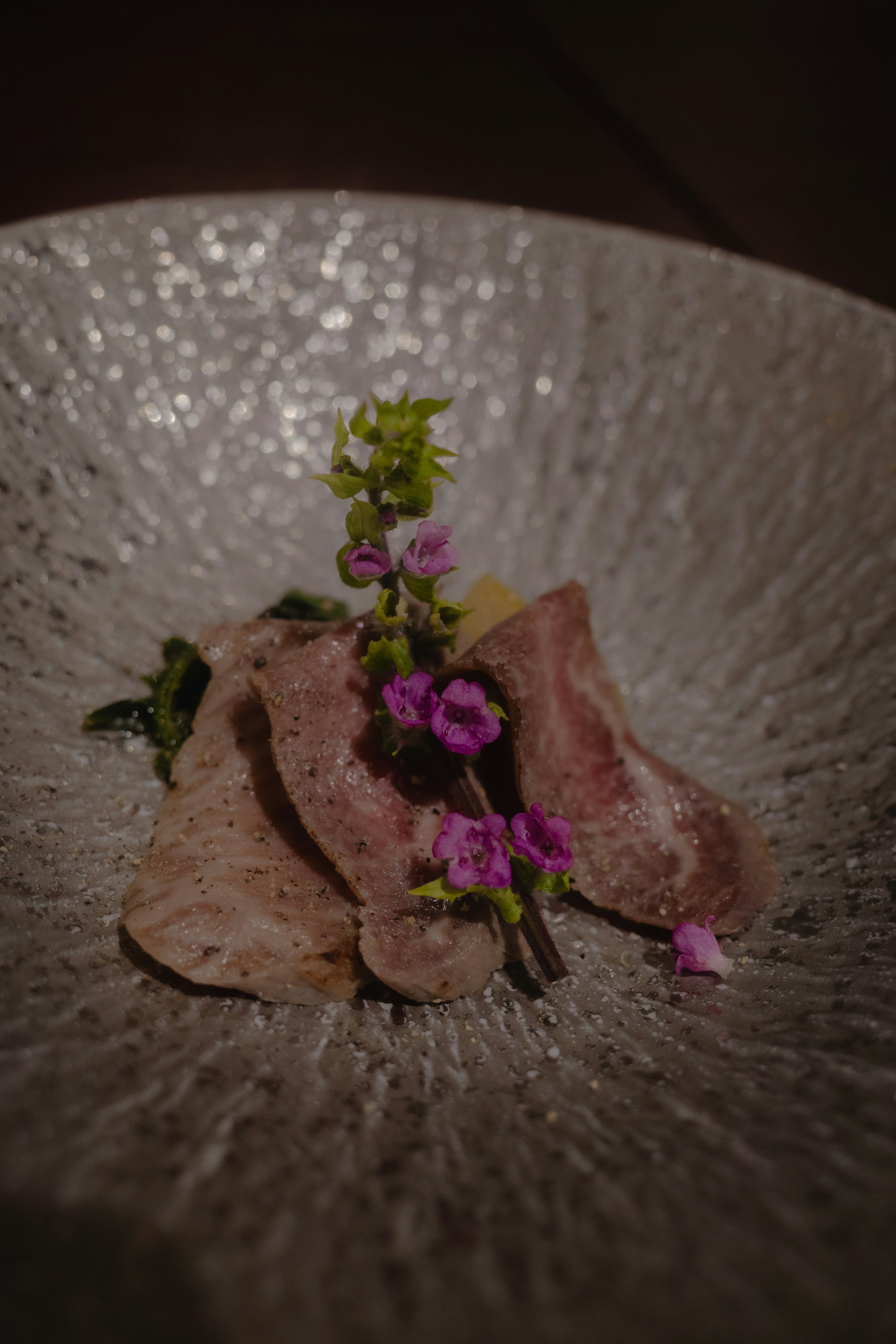 Plato de carne presentado de forma elegante adornado con flores