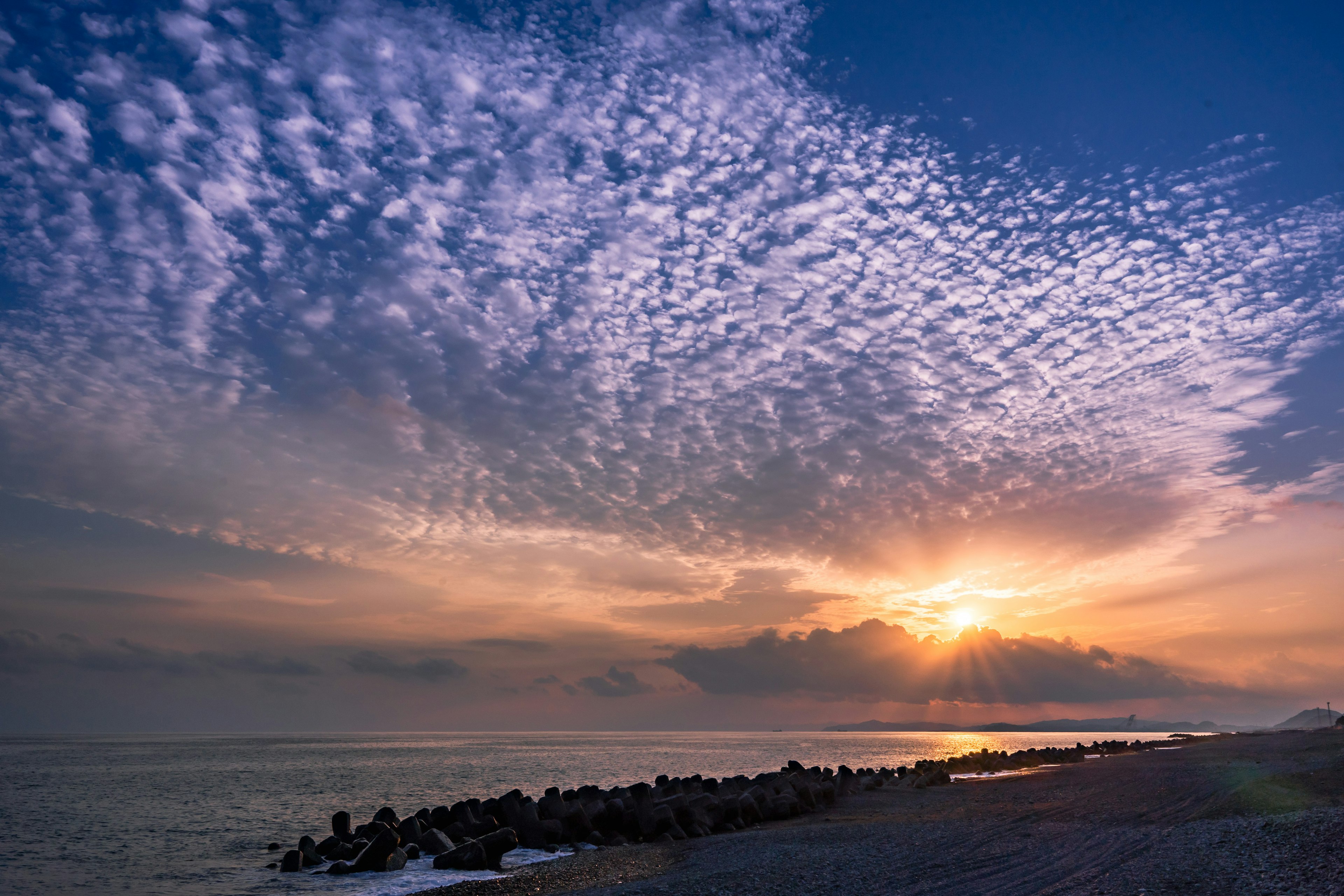 美しい夕日が海に沈む様子と色とりどりの雲