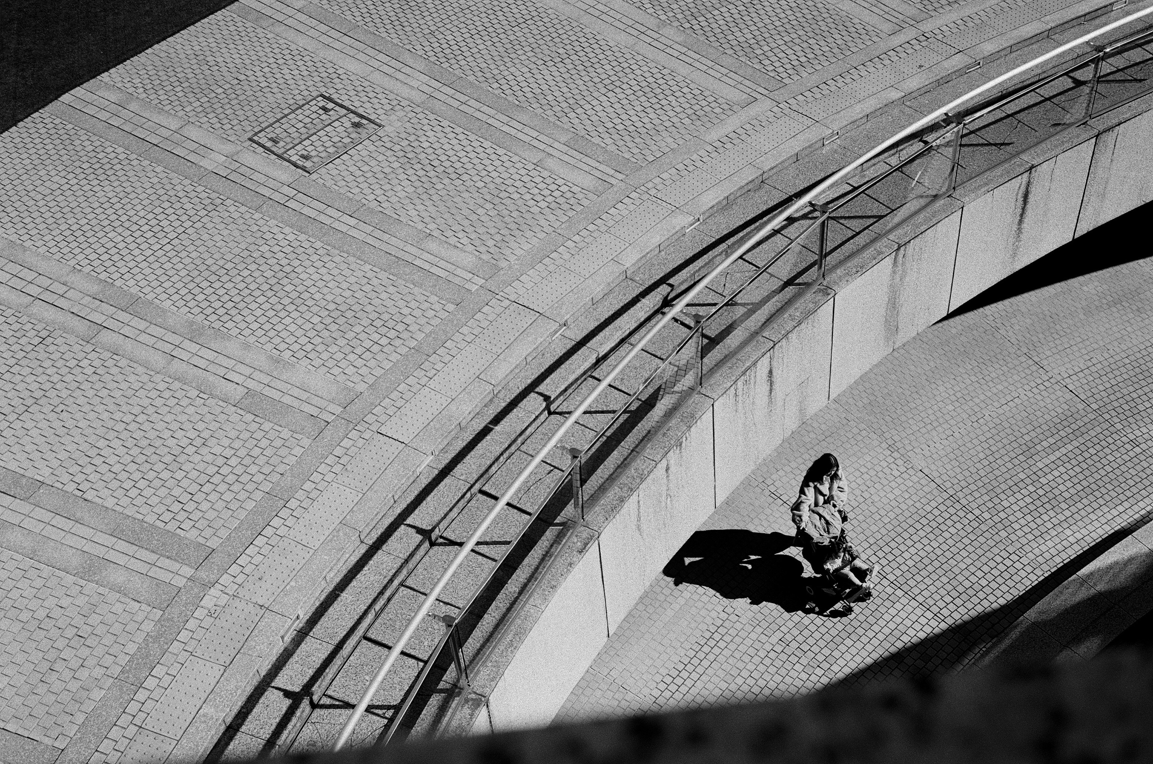 Black and white photo of a person walking on a curved pathway