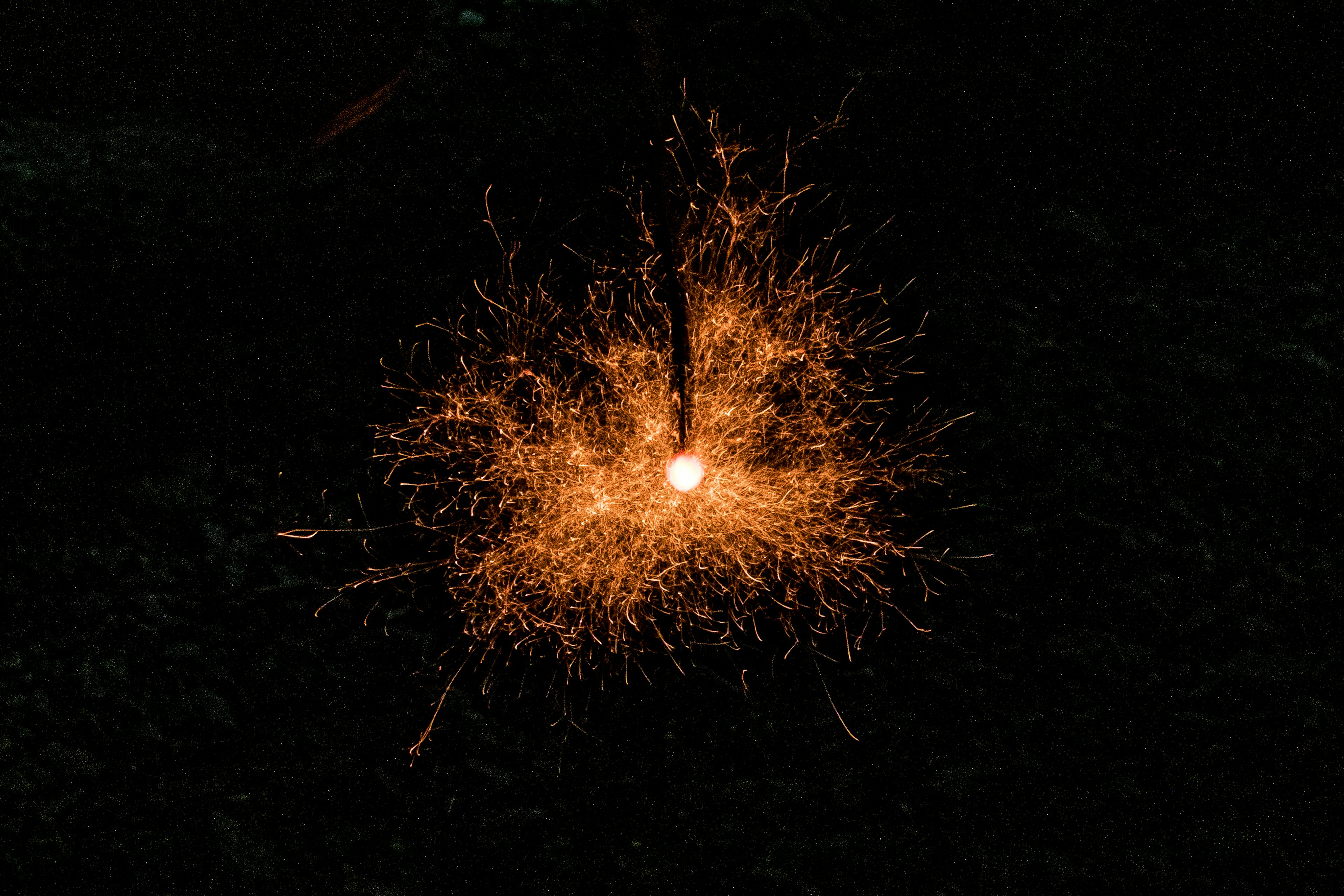 Étincelles rayonnantes sur fond sombre