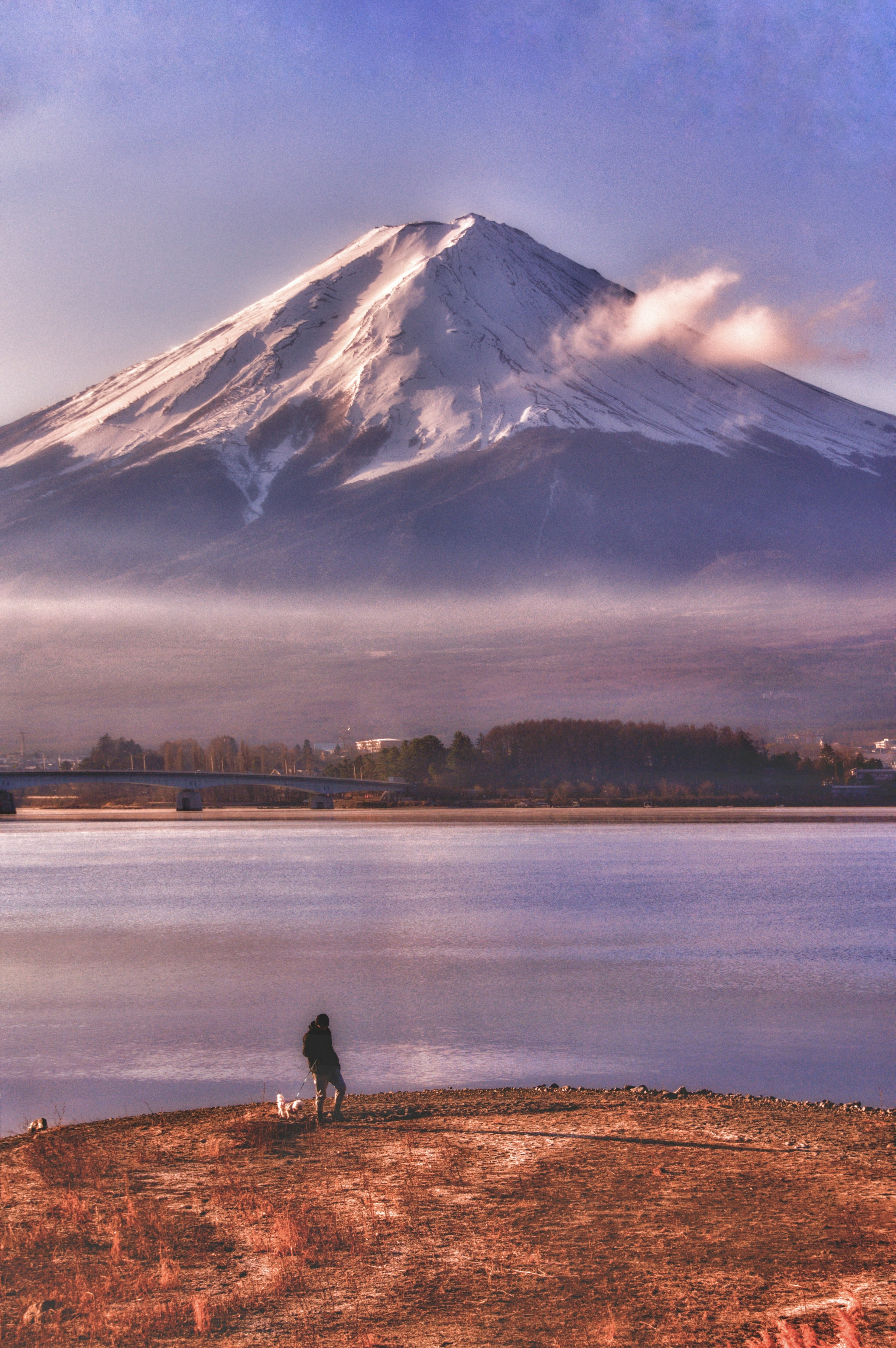 Eine malerische Aussicht auf den Fuji mit einer Person, die am See angelt