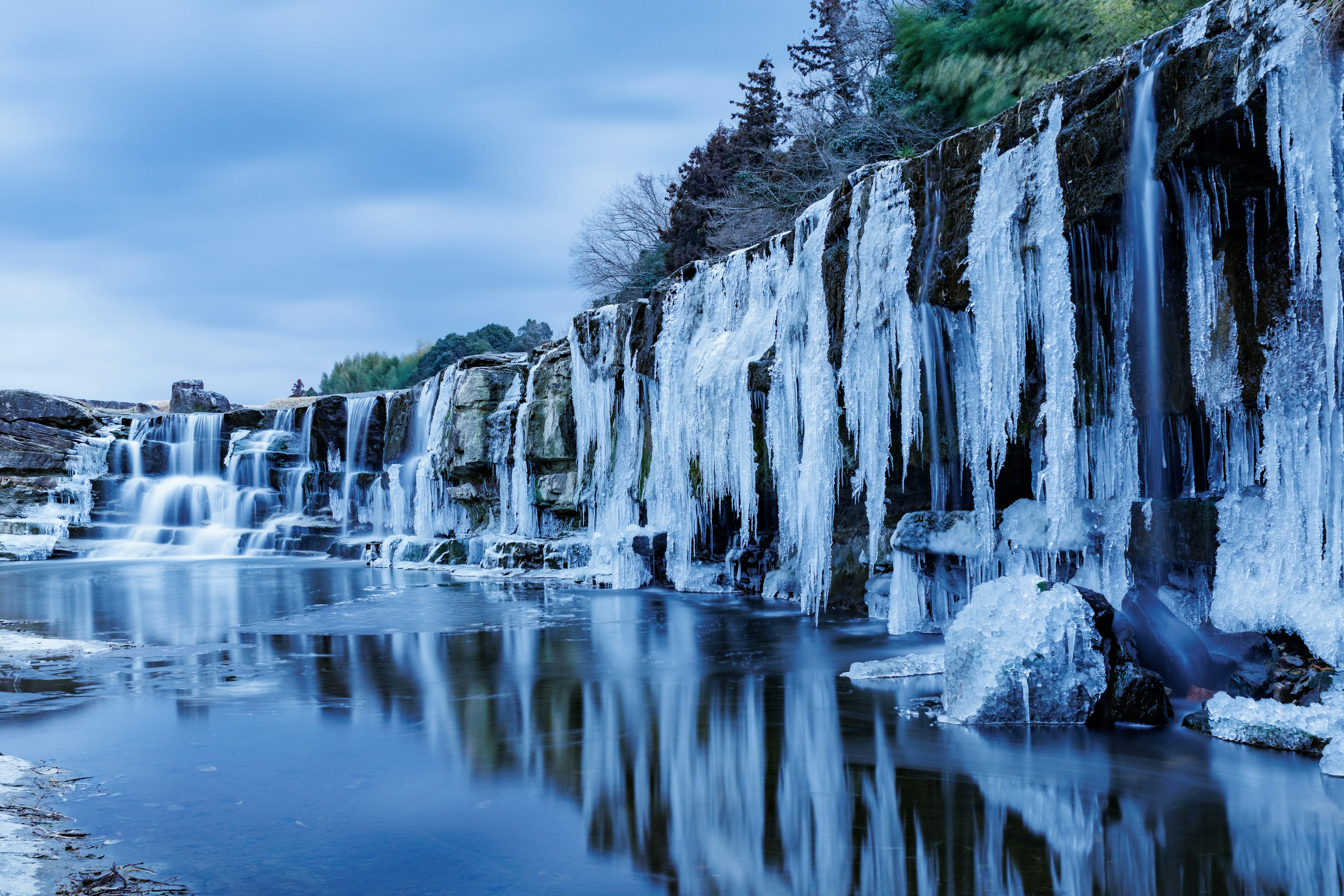 Frozen waterfall with icy formations and blue reflections